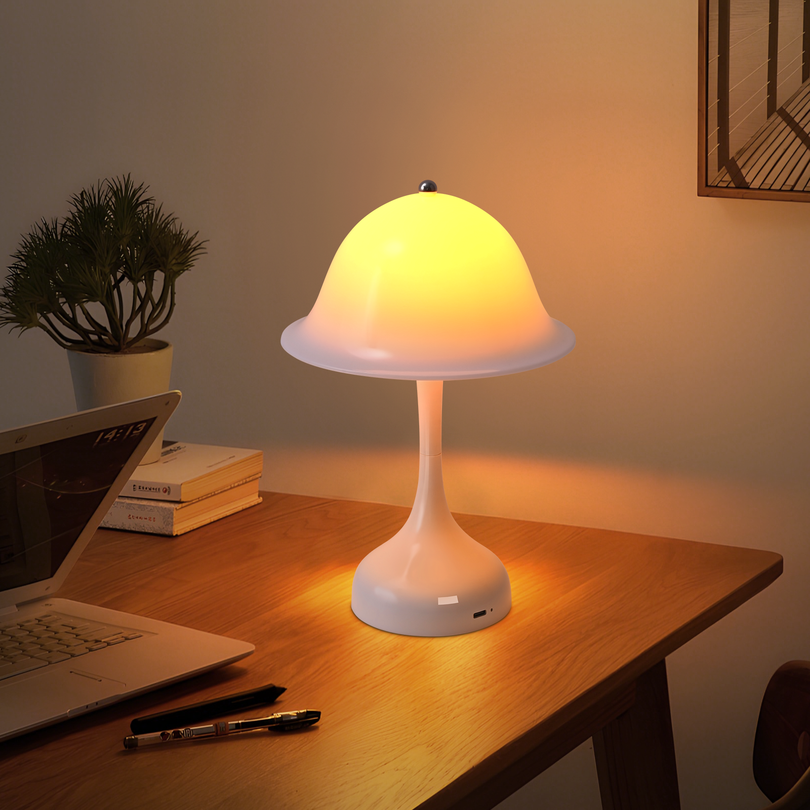 Una lampada bianca a forma di fungo illumina una scrivania in legno con laptop e libri.