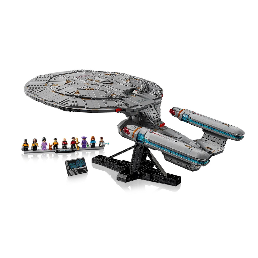Model Lego U.S.S. Enterprise na stojaku z figurkami i tabliczką.