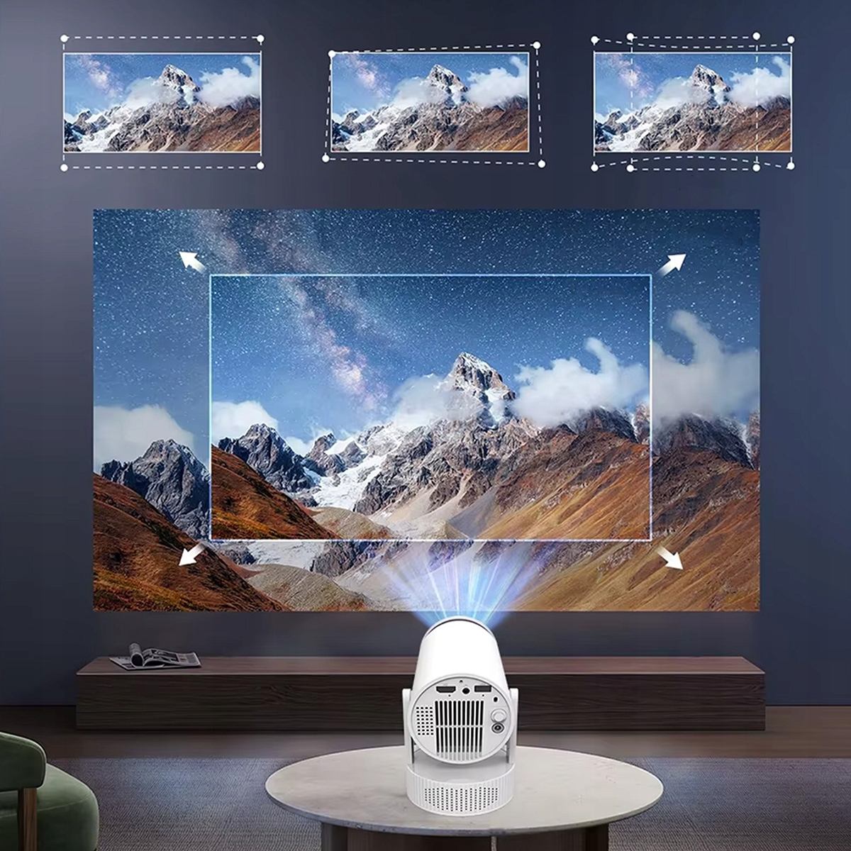 Mały biały projektor wyświetla obraz górskiego krajobrazu z gwiaździstym niebem na ekranie.