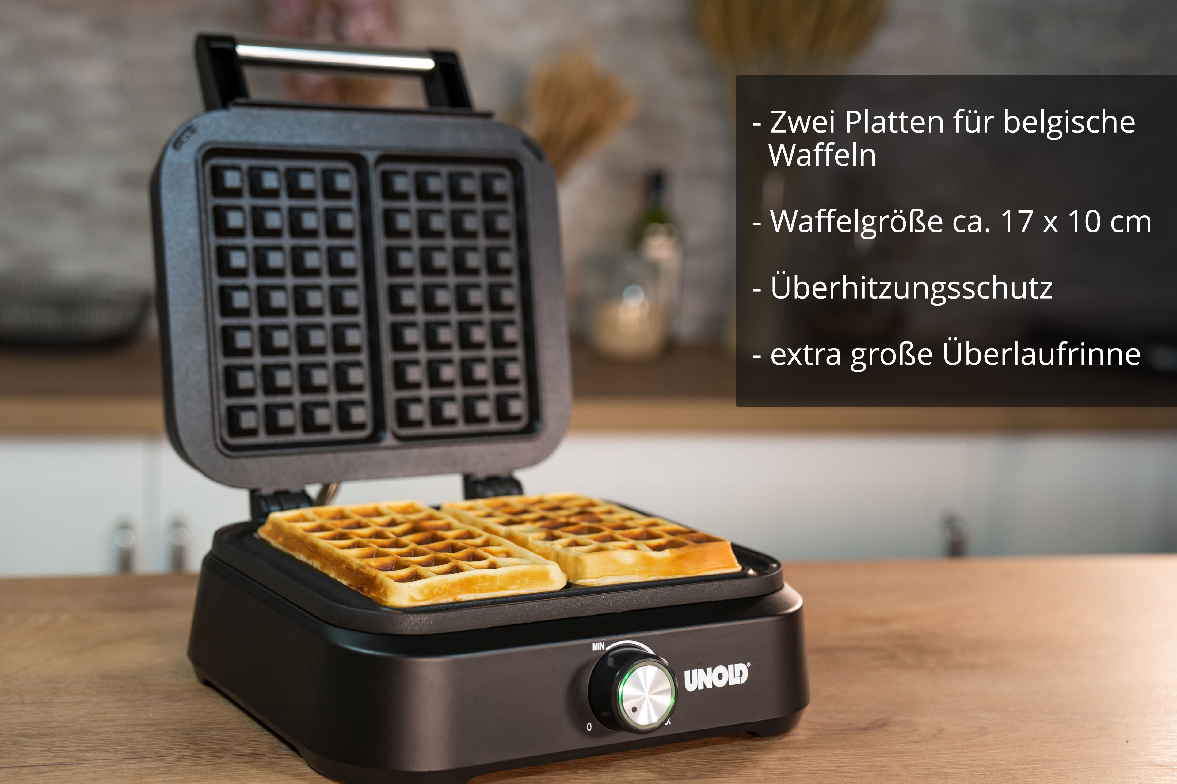 Ein offener Waffelautomat mit zwei belgischen Waffeln im Inneren.
