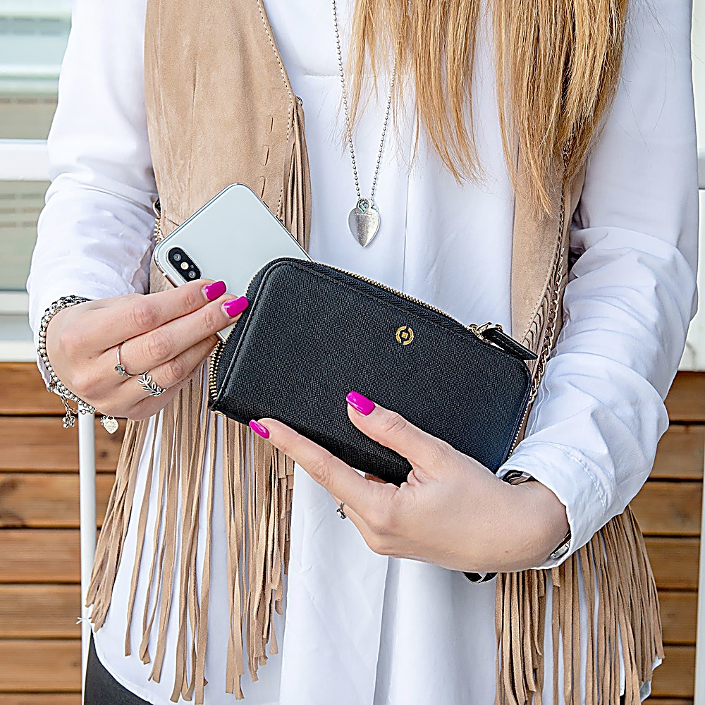 Una donna con le unghie rosa tiene un portafoglio nero e uno smartphone.