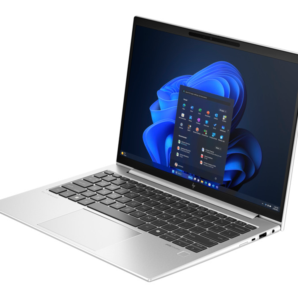 Arkadan aydınlatmalı klavyeli gümüş rengi dizüstü bilgisayar, Windows 11 arka planını gösteriyor.