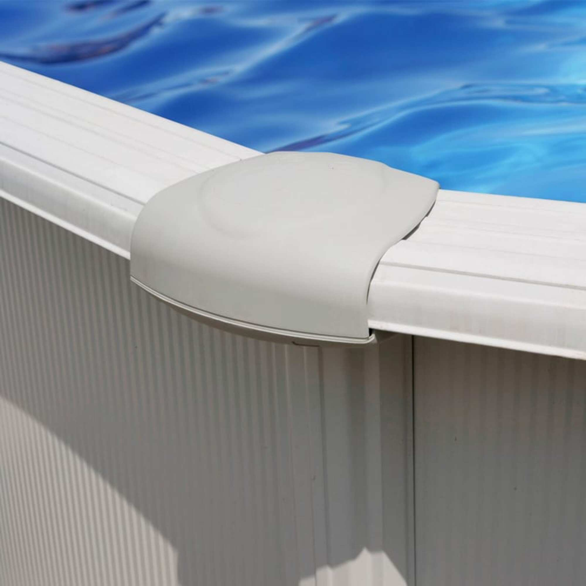 Primer plano del borde de una piscina blanca con agua azul y una esquina.