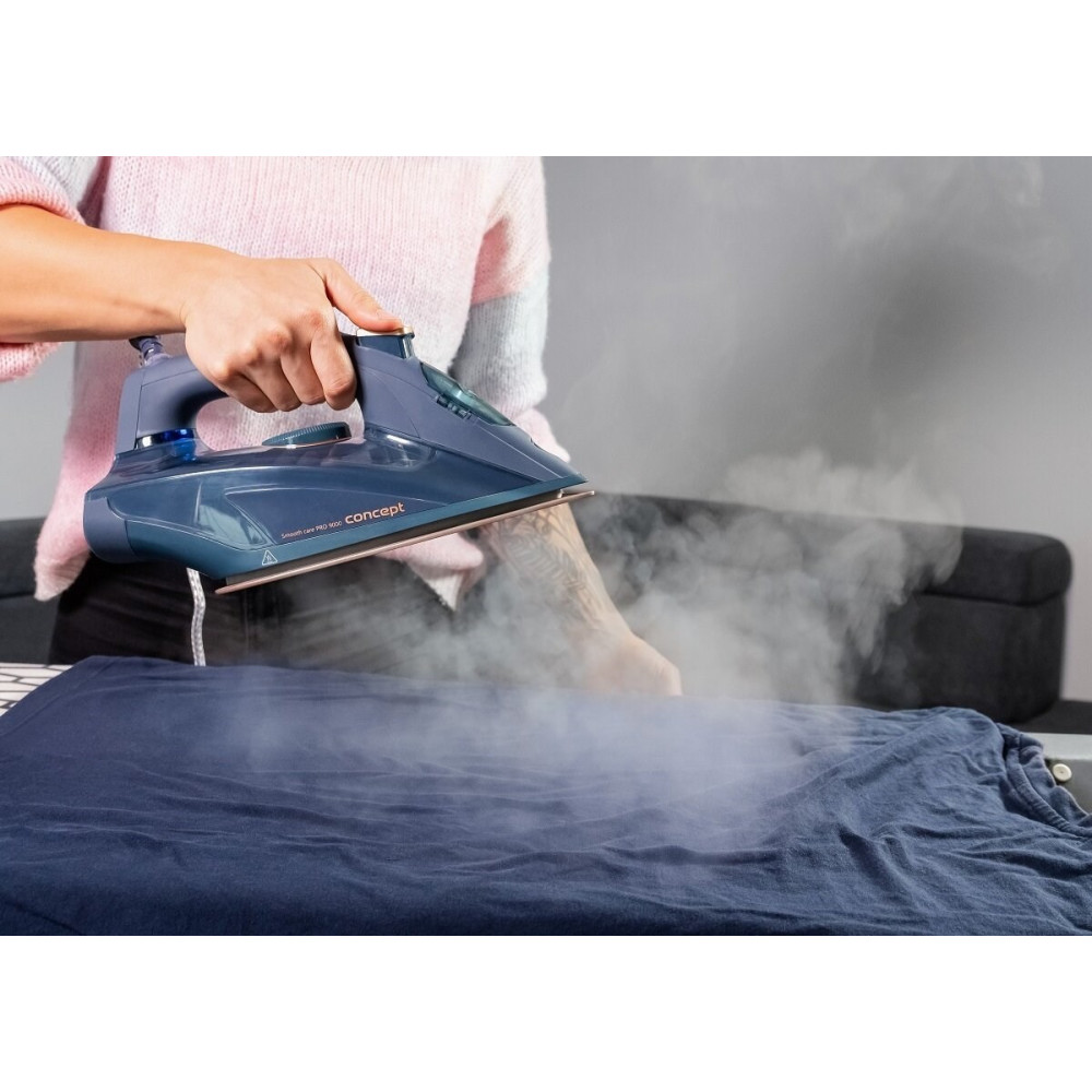 Osoba prasuje ciemnoniebieską koszulkę niebieskim żelazkiem parowym.