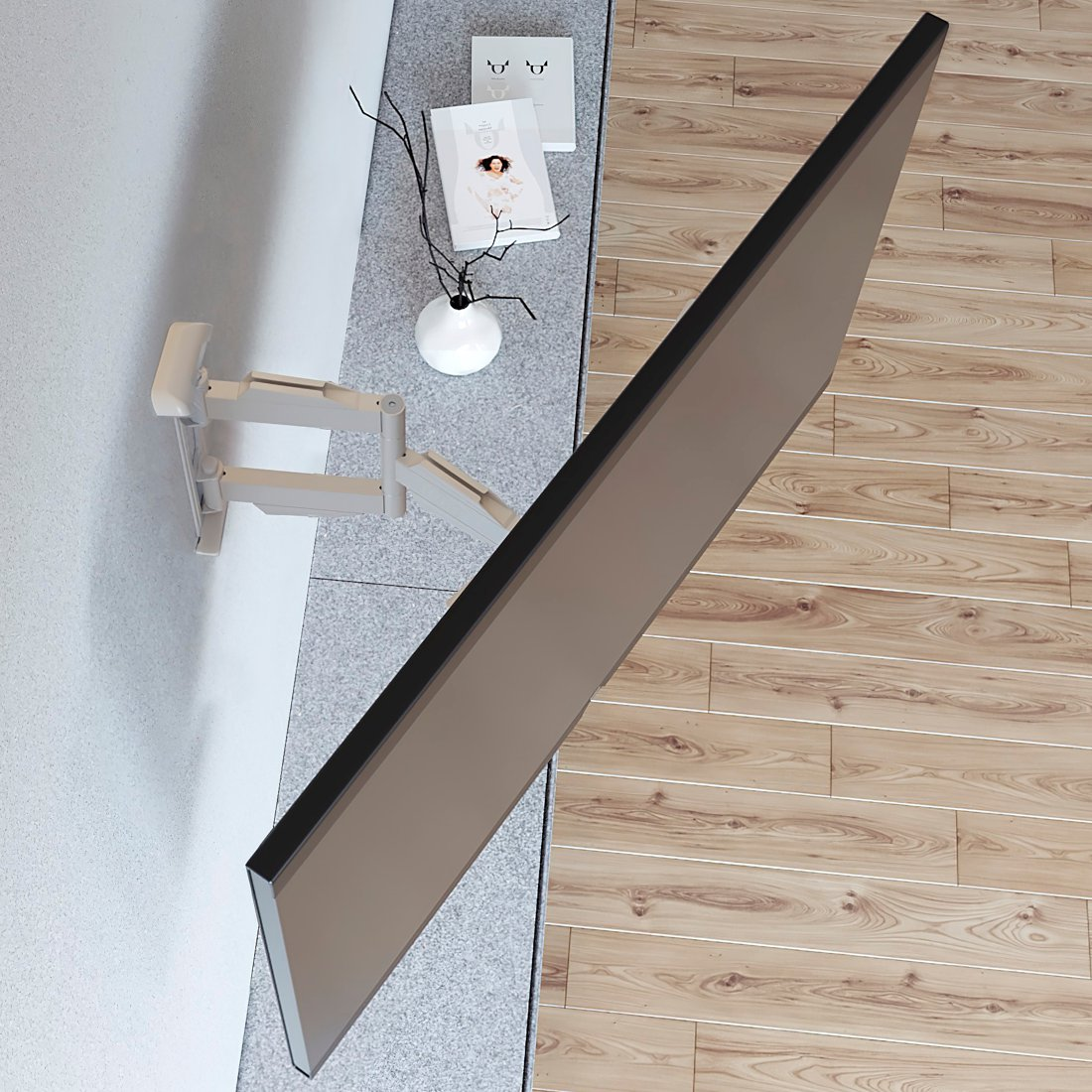 Biały uchwyt ścienny do telewizora, obok półka z dekoracjami.