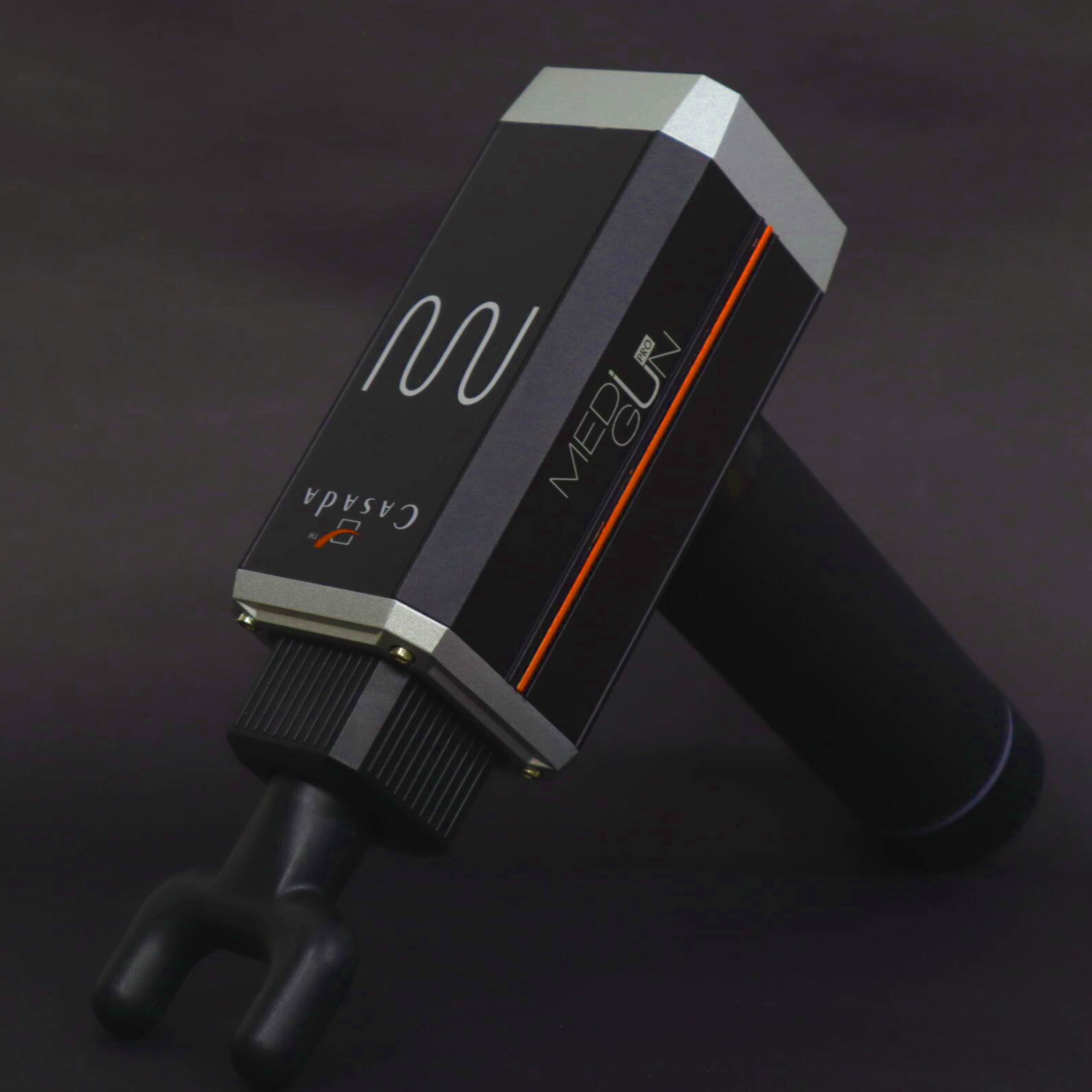 Czarny pistolet do masażu ze srebrnymi akcentami leży na ciemnym tle.