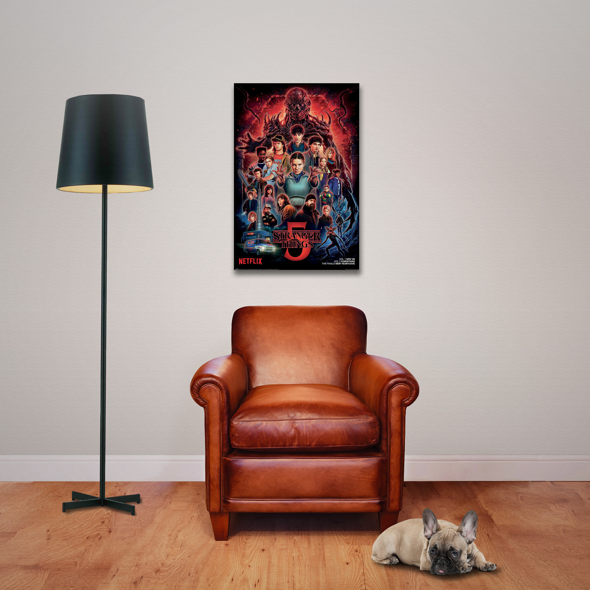 Ein brauner Ledersessel steht vor einem Poster von Stranger Things, neben einer Stehlampe.