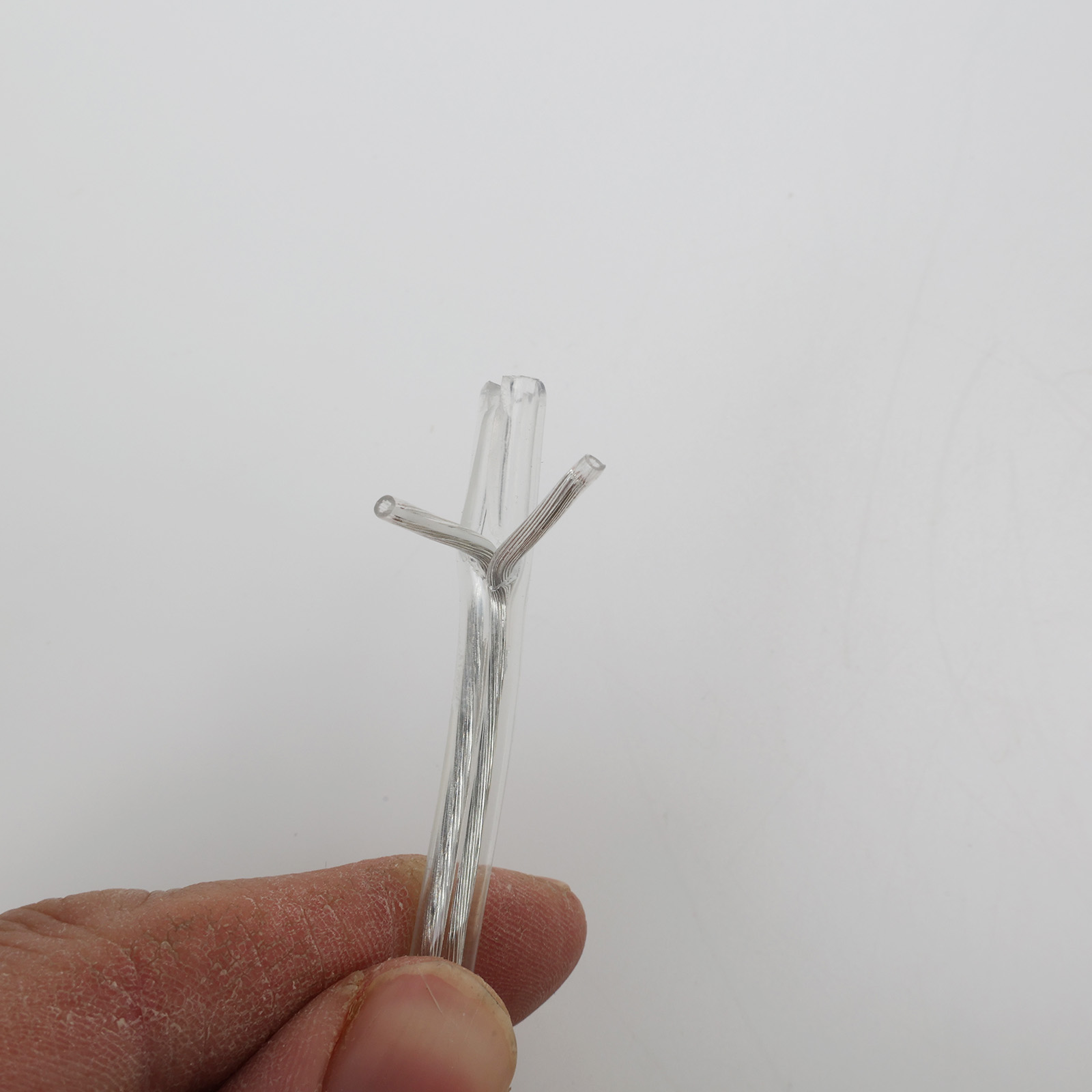 Una mano sujeta un tubo de plástico transparente con cables.