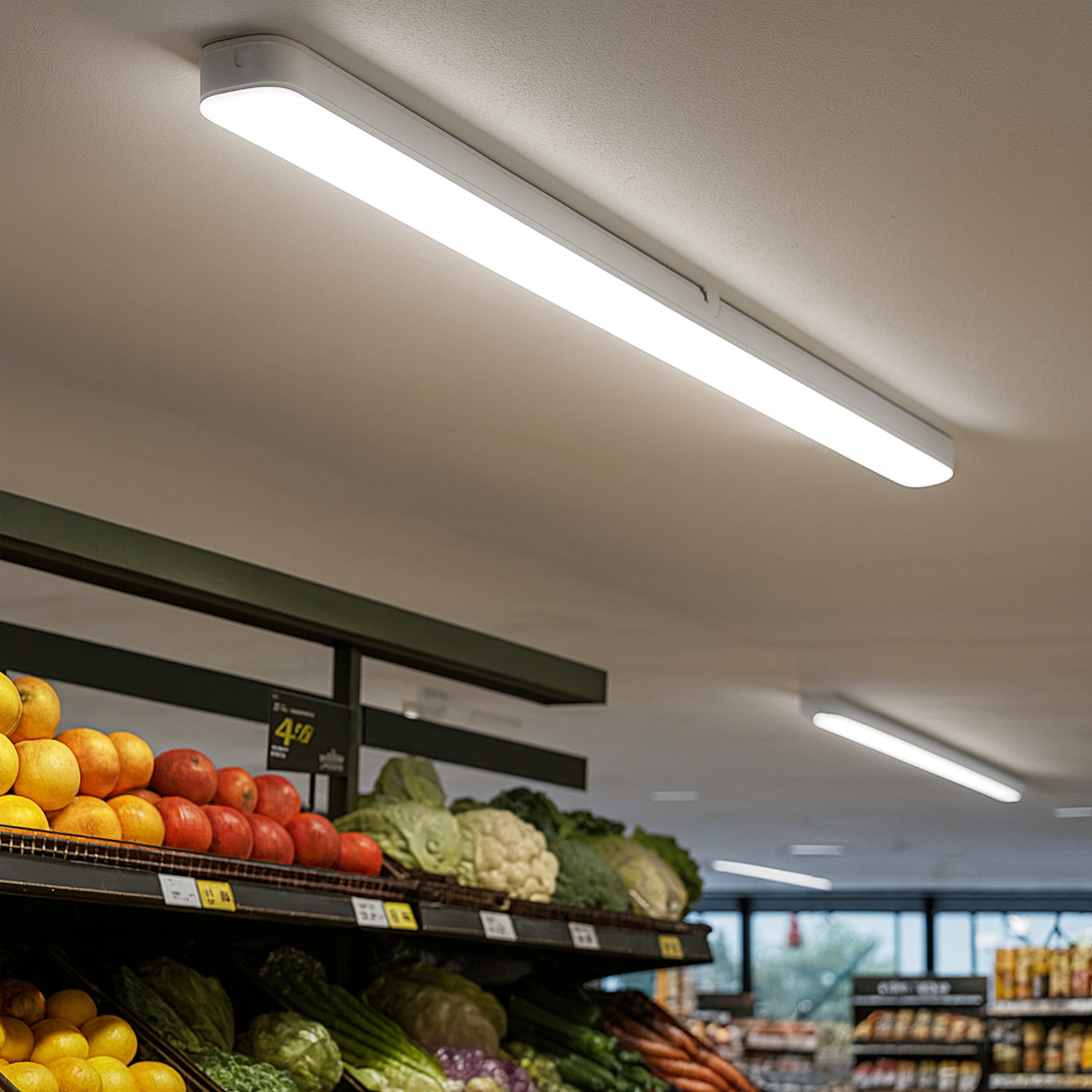 Estantes de productos con frutas y verduras, iluminados por largas luces fluorescentes.