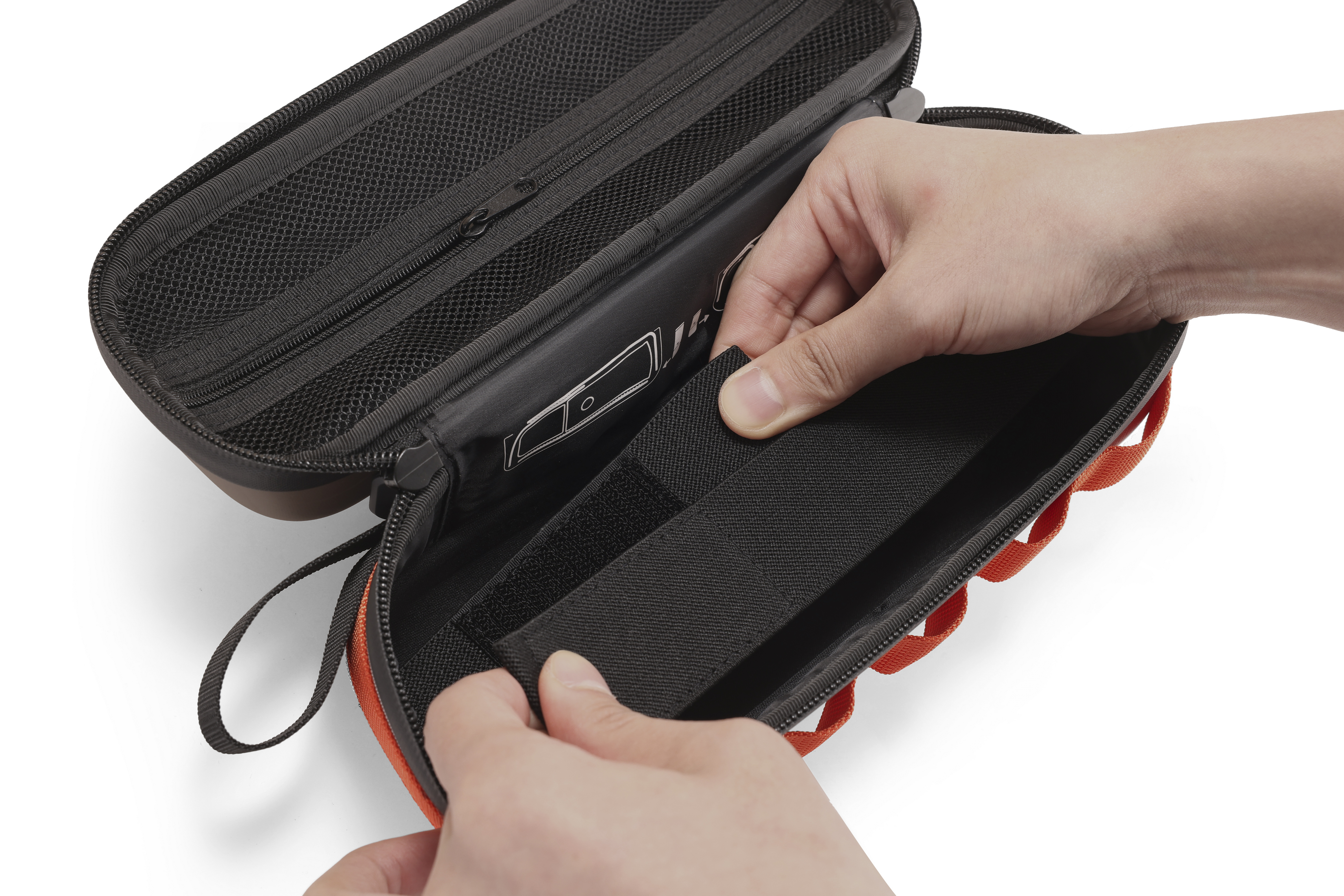 Hände schließen eine schwarze Tasche mit orangefarbenen Schlaufen. Mesh-Futter sichtbar.
