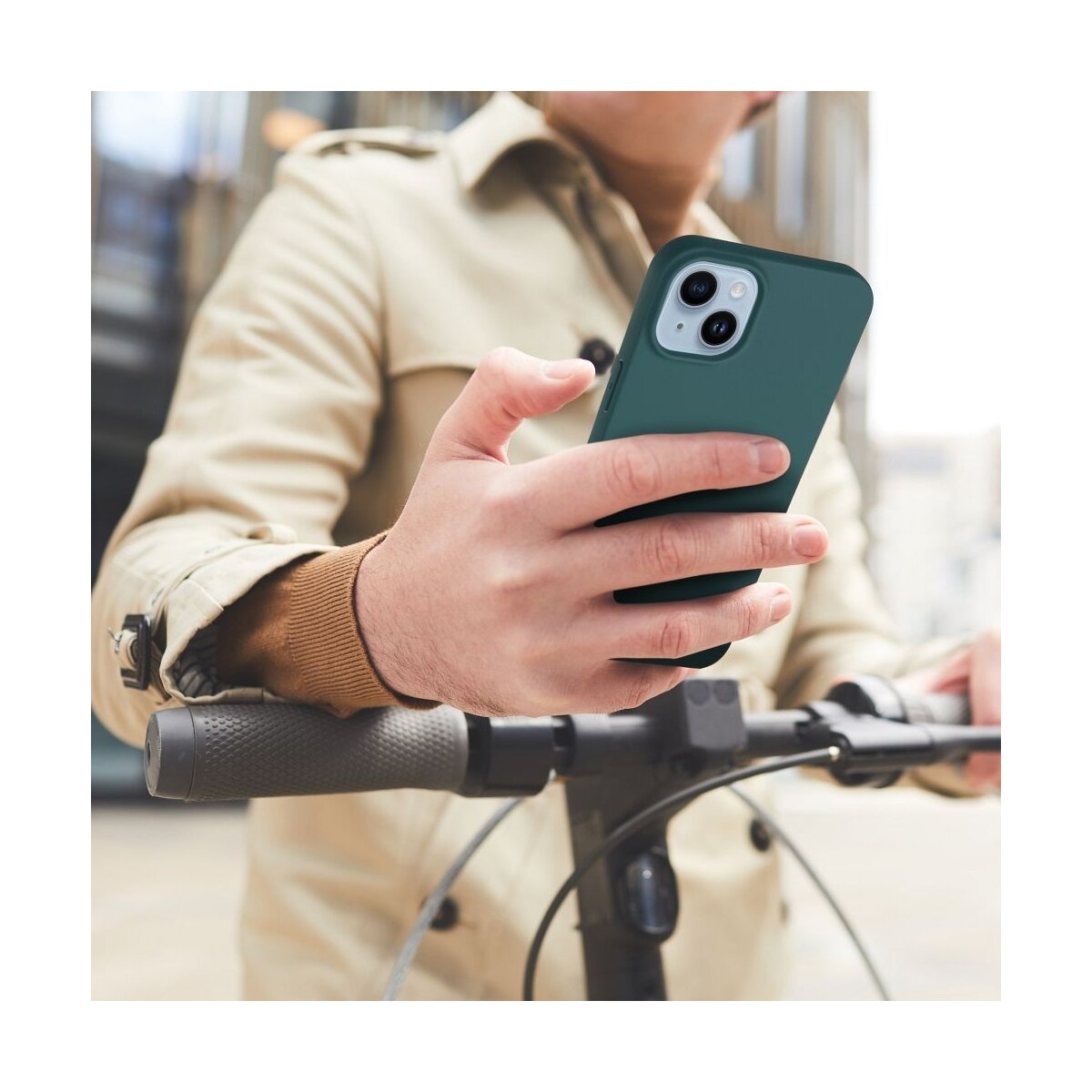 Persona tiene un telefono verde scuro davanti al manubrio di un monopattino.