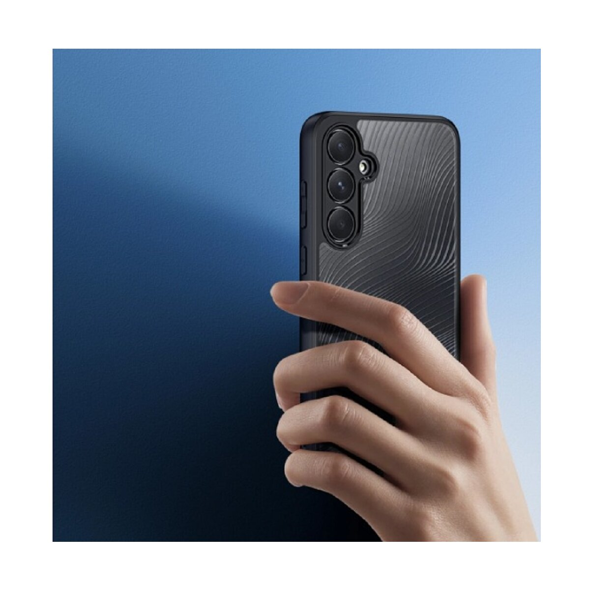 Una mano tiene un telefono nero con tre fotocamere. Motivo a onde sul retro.