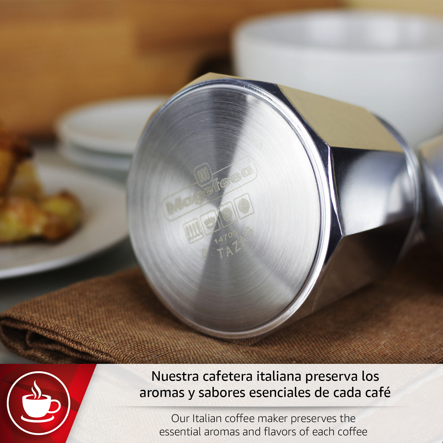 Una cafetera italiana plateada sobre tela marrón. Platos al fondo.