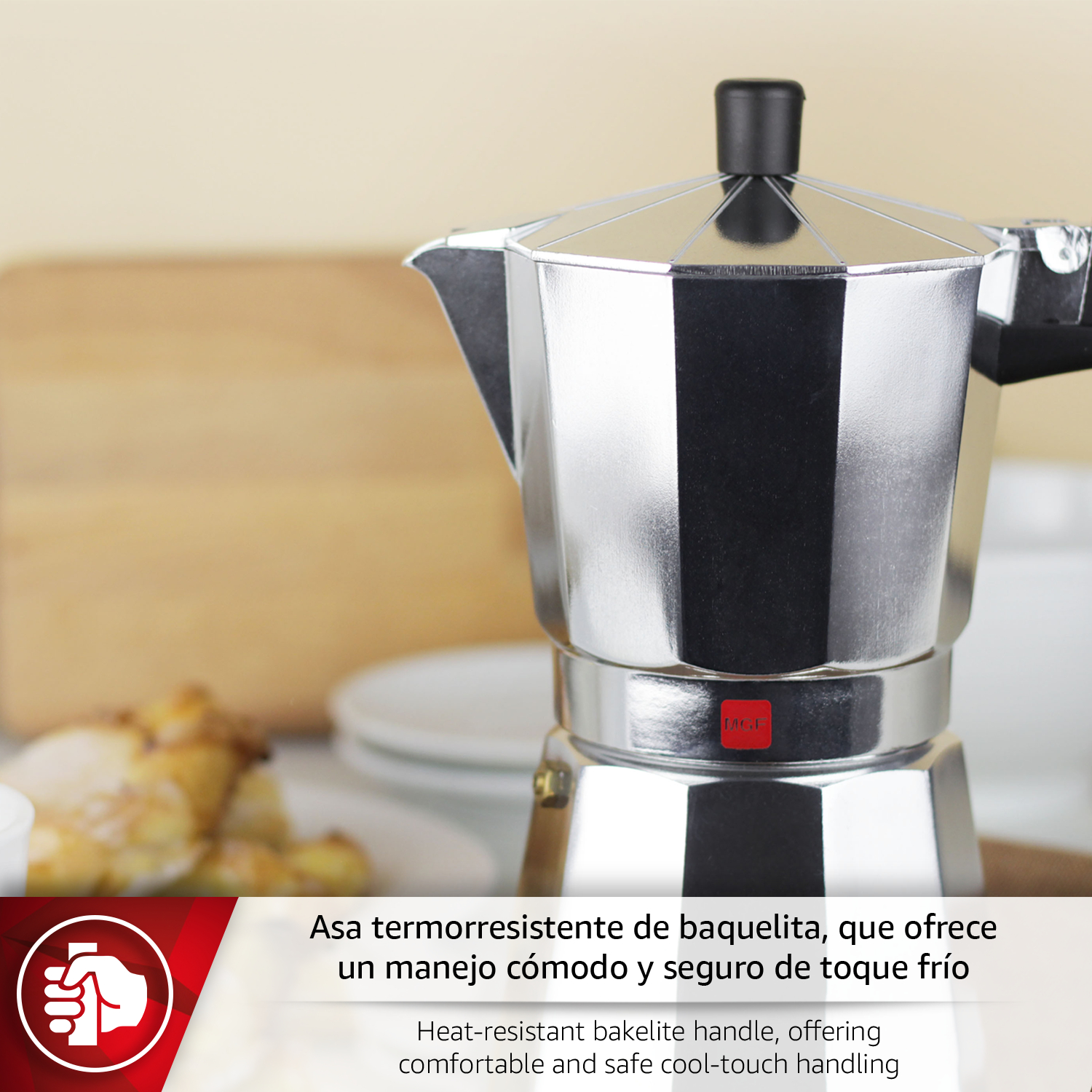 Una cafetera Moka plateada con asa negra sobre una mesa.