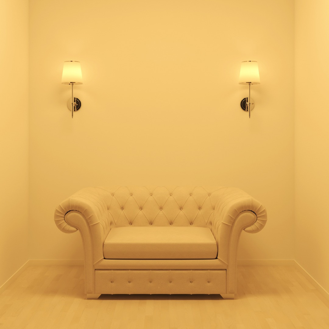 Un sofá amarillo claro frente a una pared amarilla clara con dos apliques.