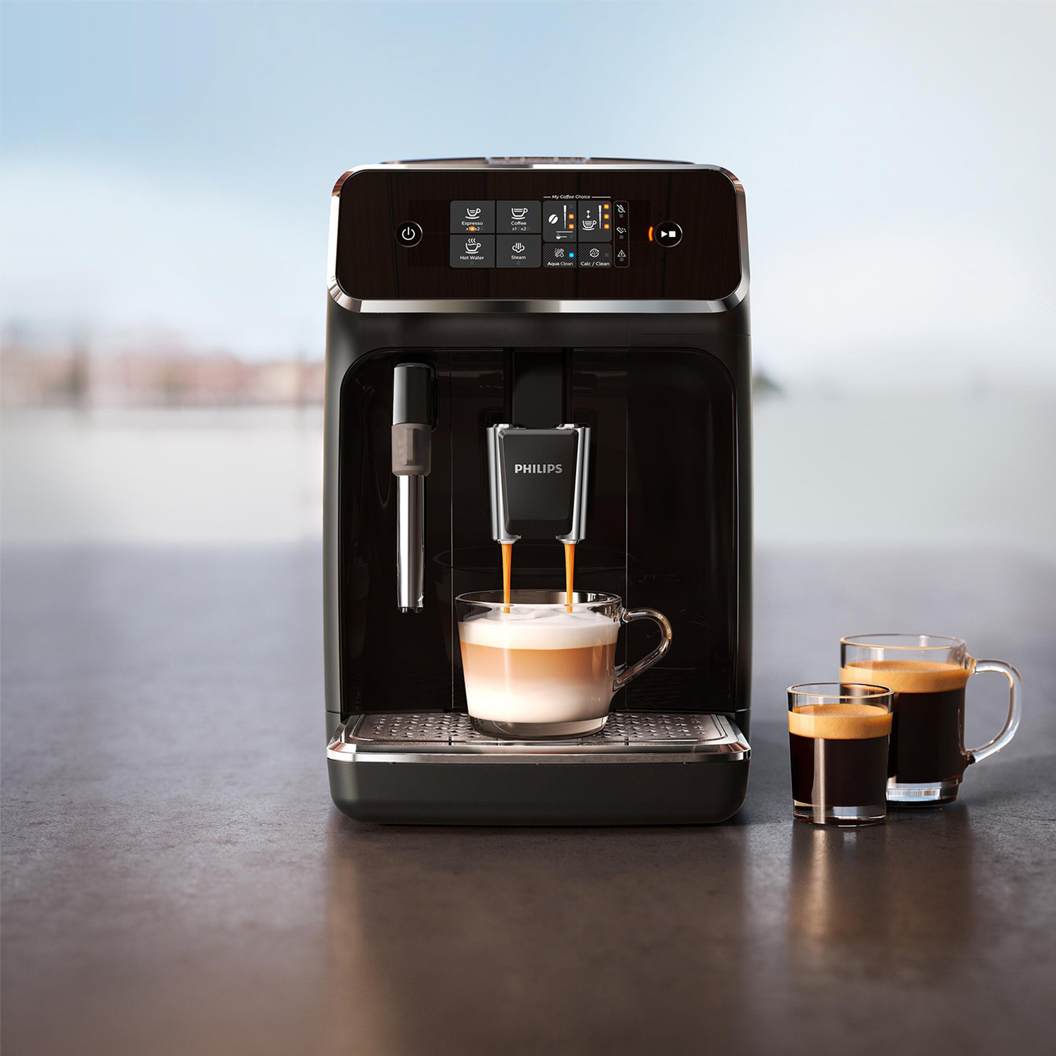 Una cafetera Philips negra prepara café en un vaso, con dos espressos al lado.