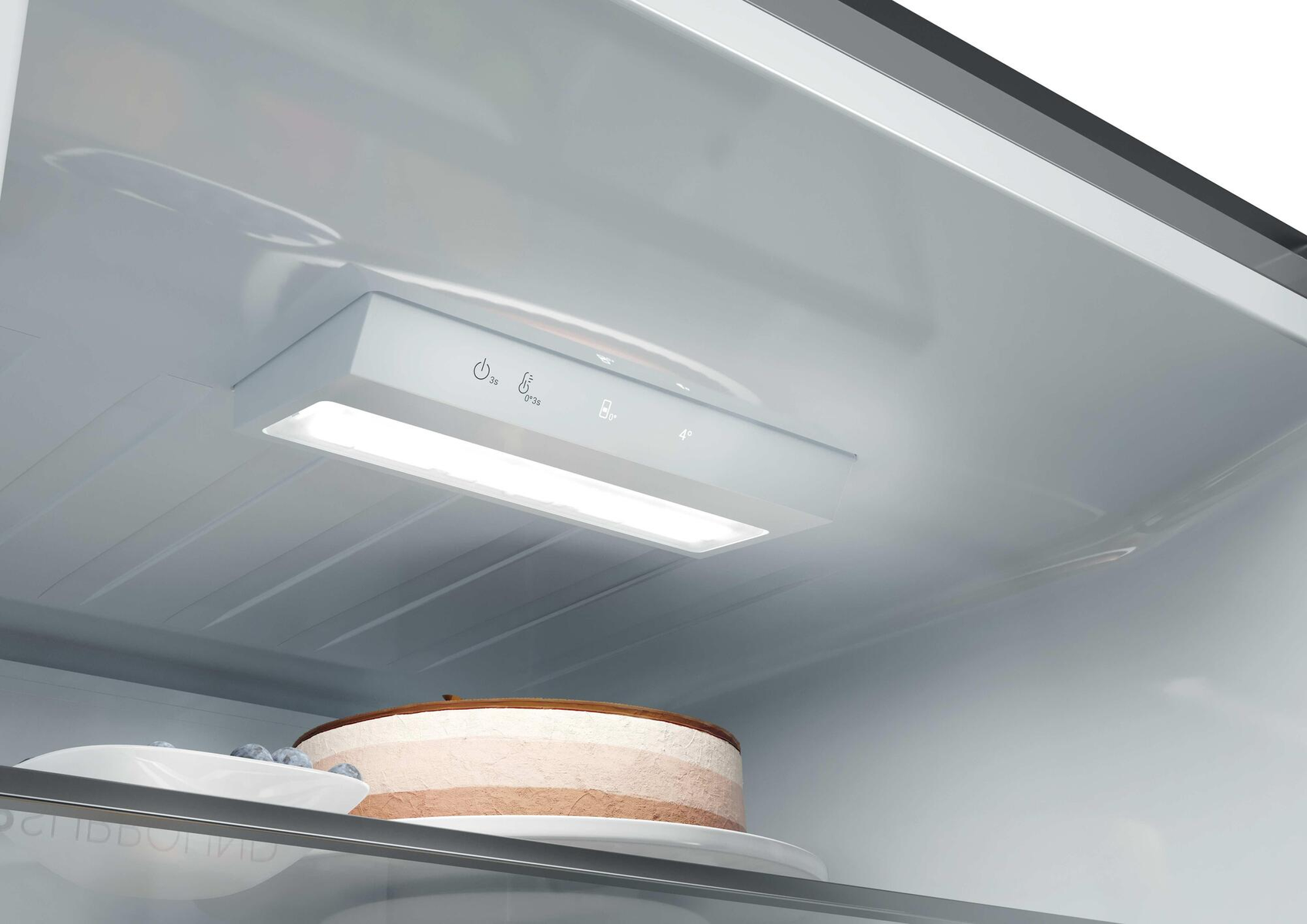 Wielowarstwowy tort z jagodami na półce w lodówce.