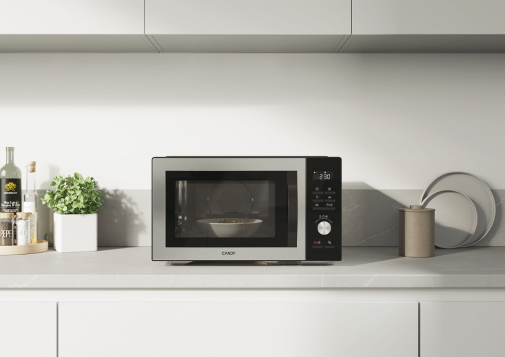 Srebrna mikrofalówka z czarnym frontem, jedzenie w środku. Obok zielona doniczka.