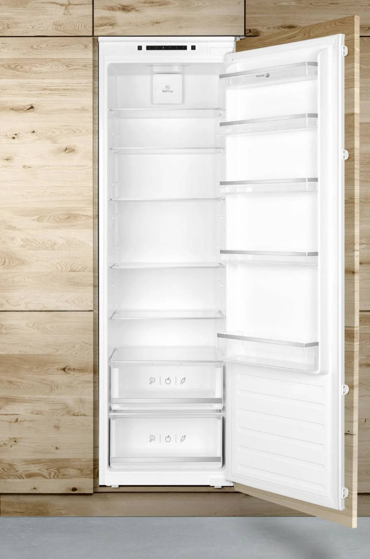 Frigorifero bianco aperto con sfondo in legno, ripiani e cassetti visibili.