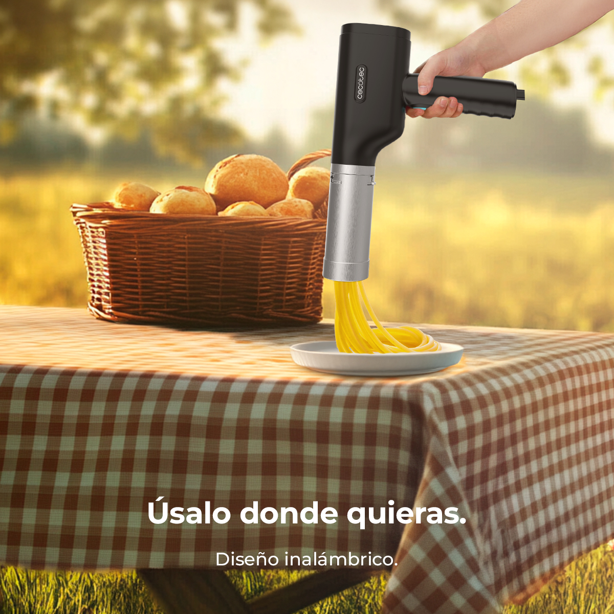 Una macchina per la pasta nera che estrude pasta gialla su un tavolo da picnic.