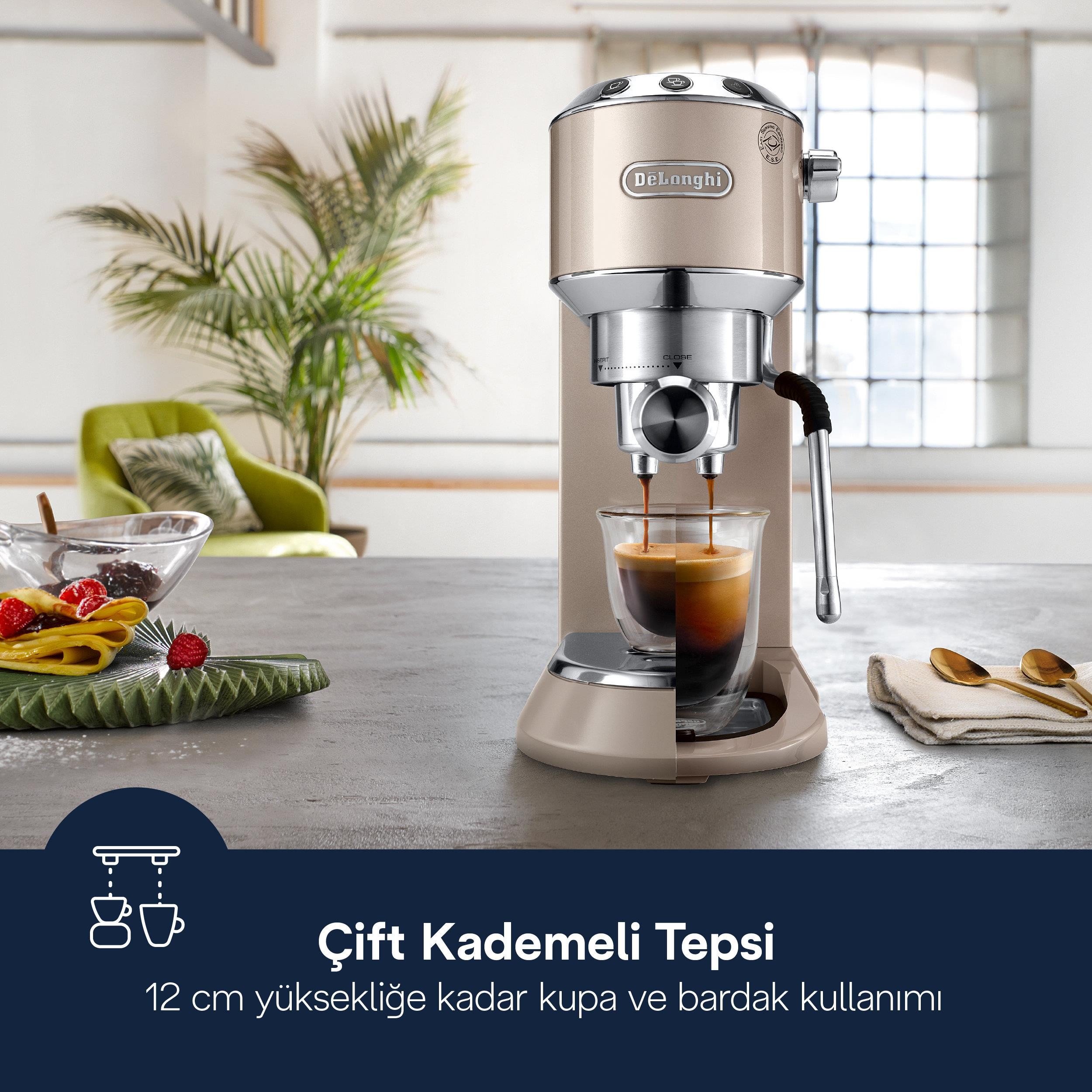 Eine beige DeLonghi Espressomaschine brüht Kaffee in ein Glas. Links ein grüner Sessel.