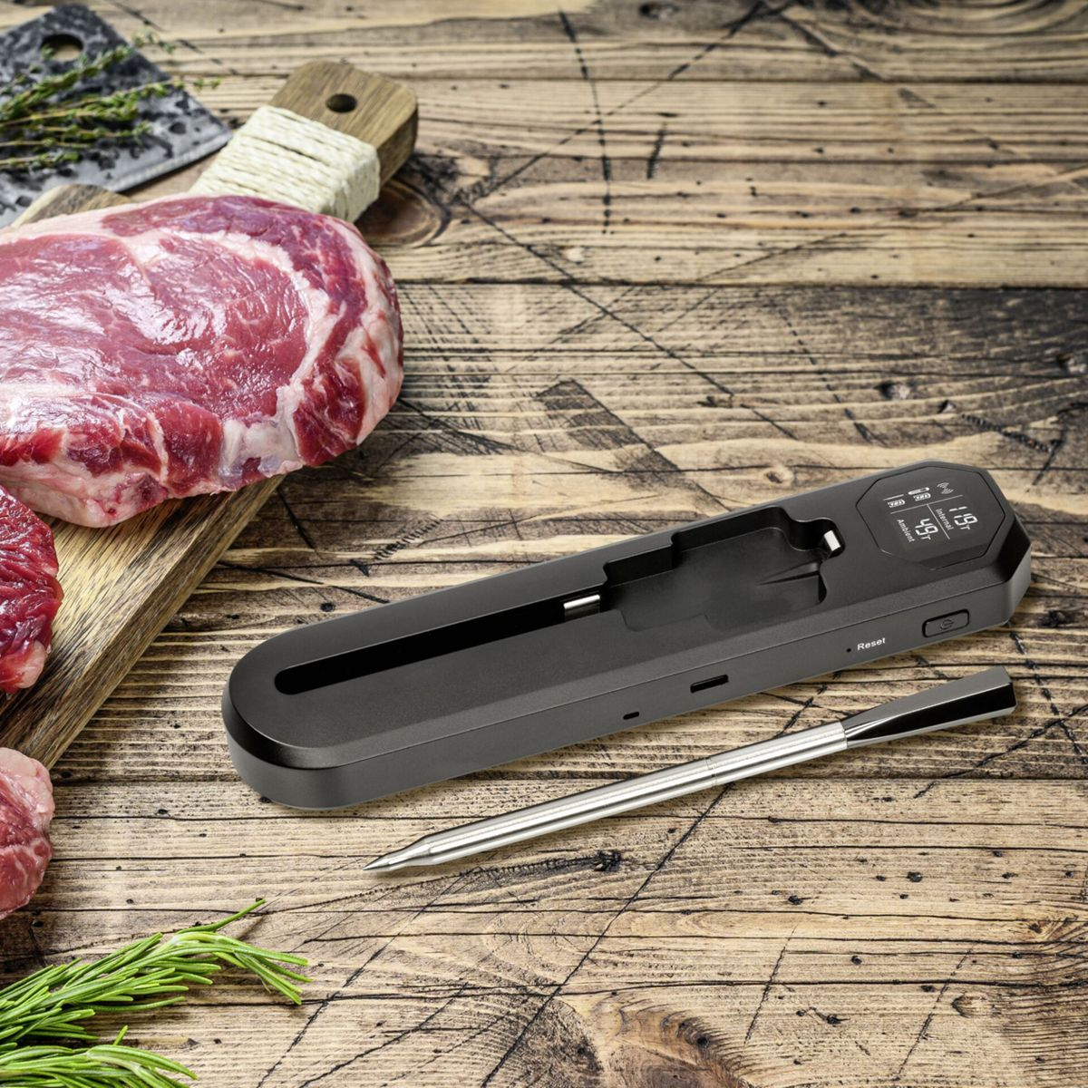 Rohes Rindfleisch und ein digitaler Fleischthermometer auf einem Holztisch.