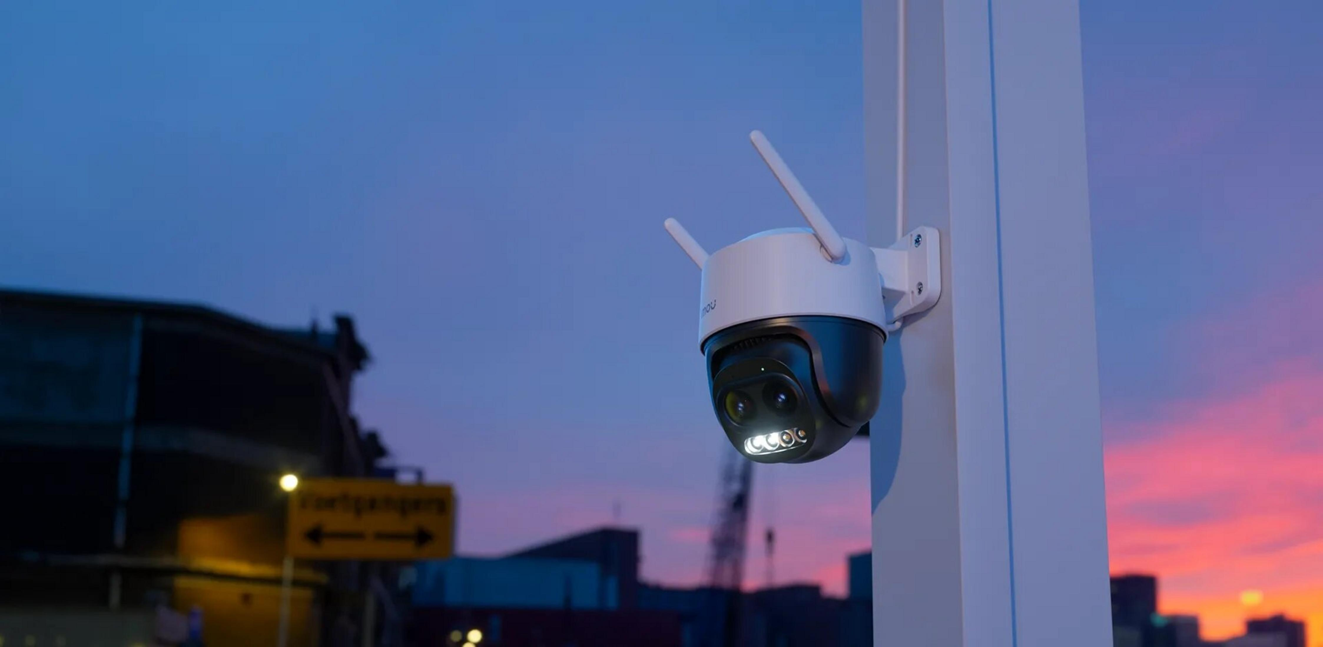 A security camera with antennas on a pole at sunset.