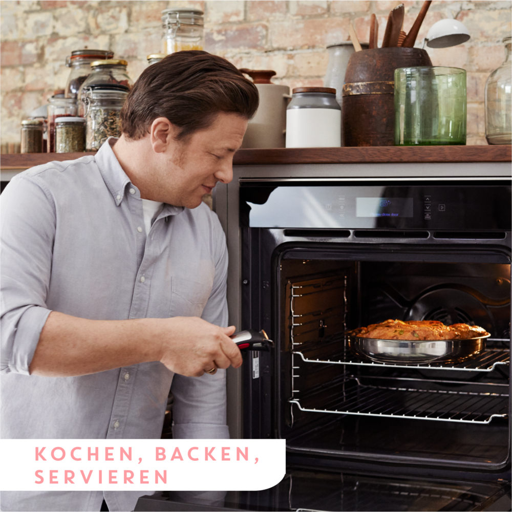 Un homme vérifie un rôti dans un four. Cuisine avec étagères et bocaux.