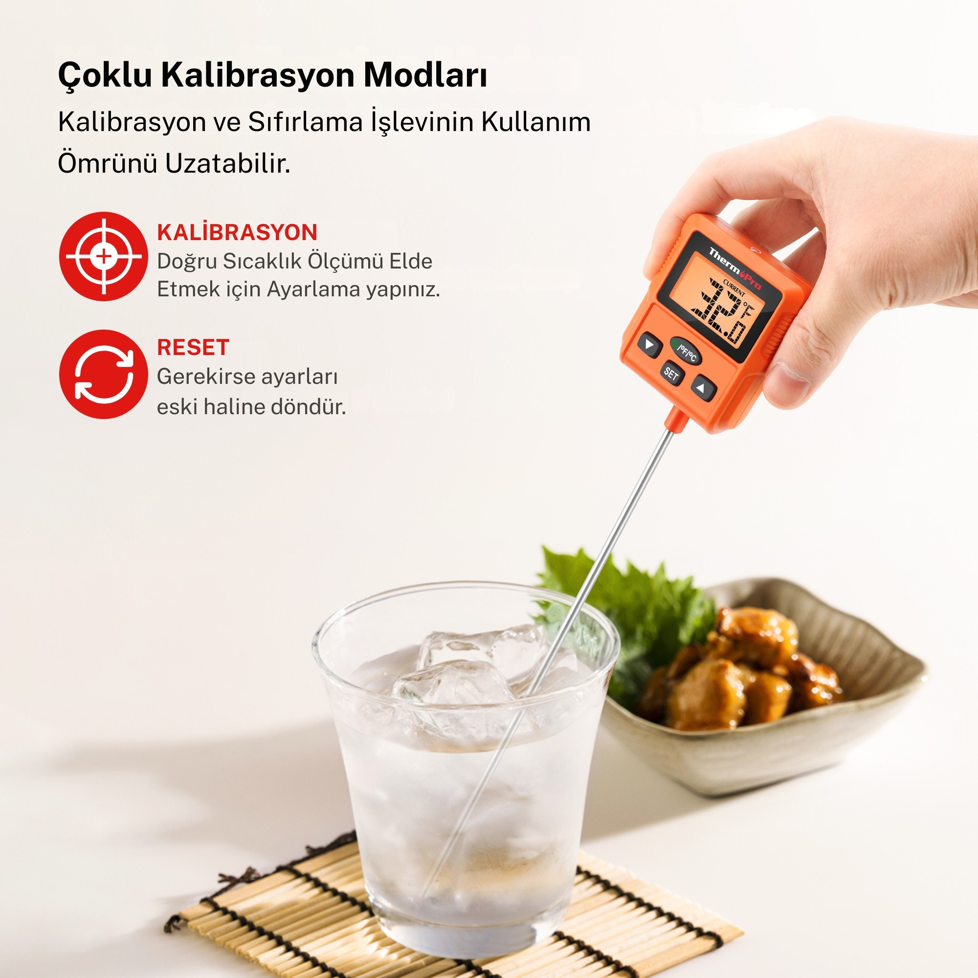 Bir el, buzlu su ve yemeğin olduğu bardağa daldırılmış turuncu bir termometre tutuyor.