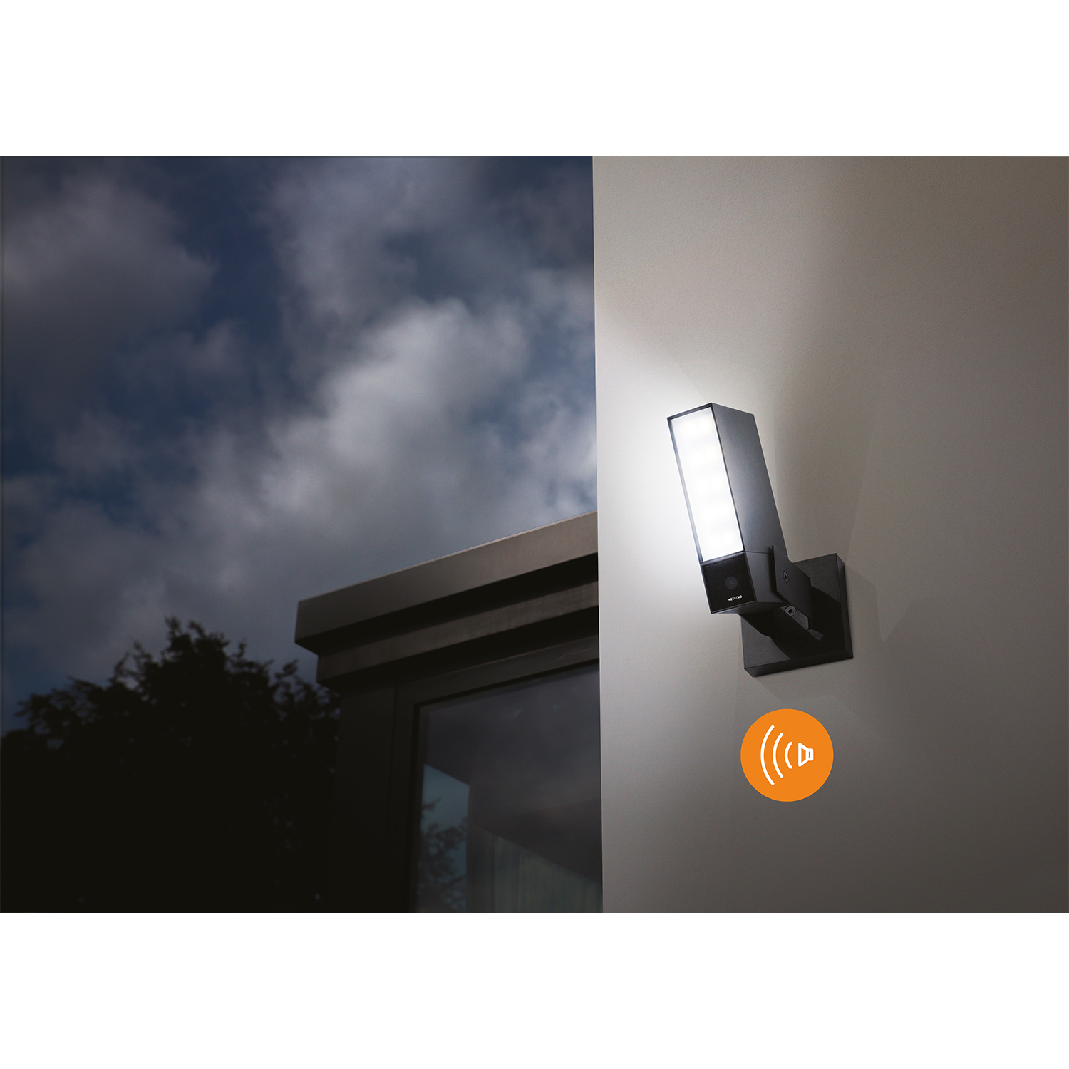 Czarna lampa zewnętrzna z czujnikiem ruchu oświetla ścianę.