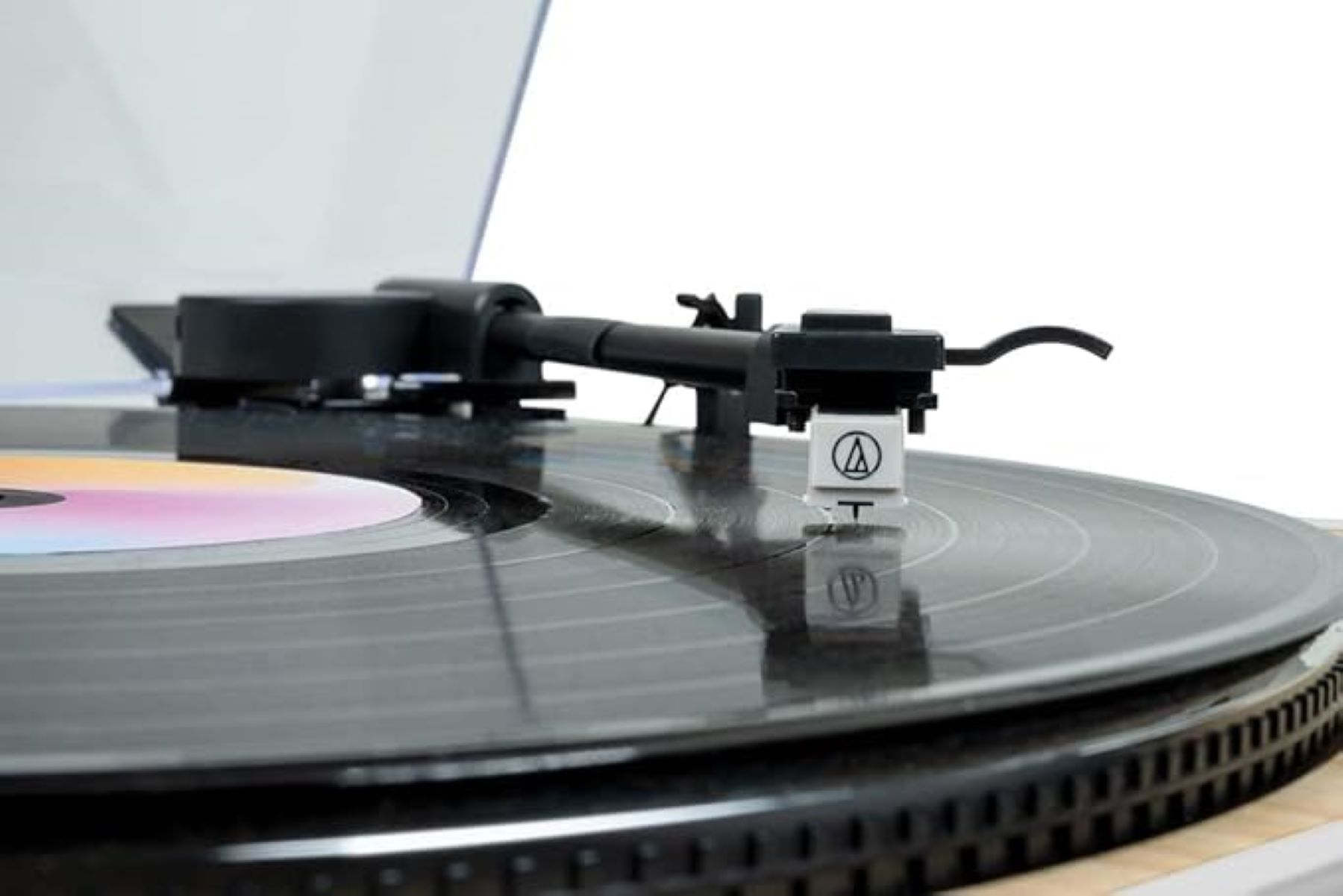 Brazo de aguja sobre un disco de vinilo con etiqueta de color.