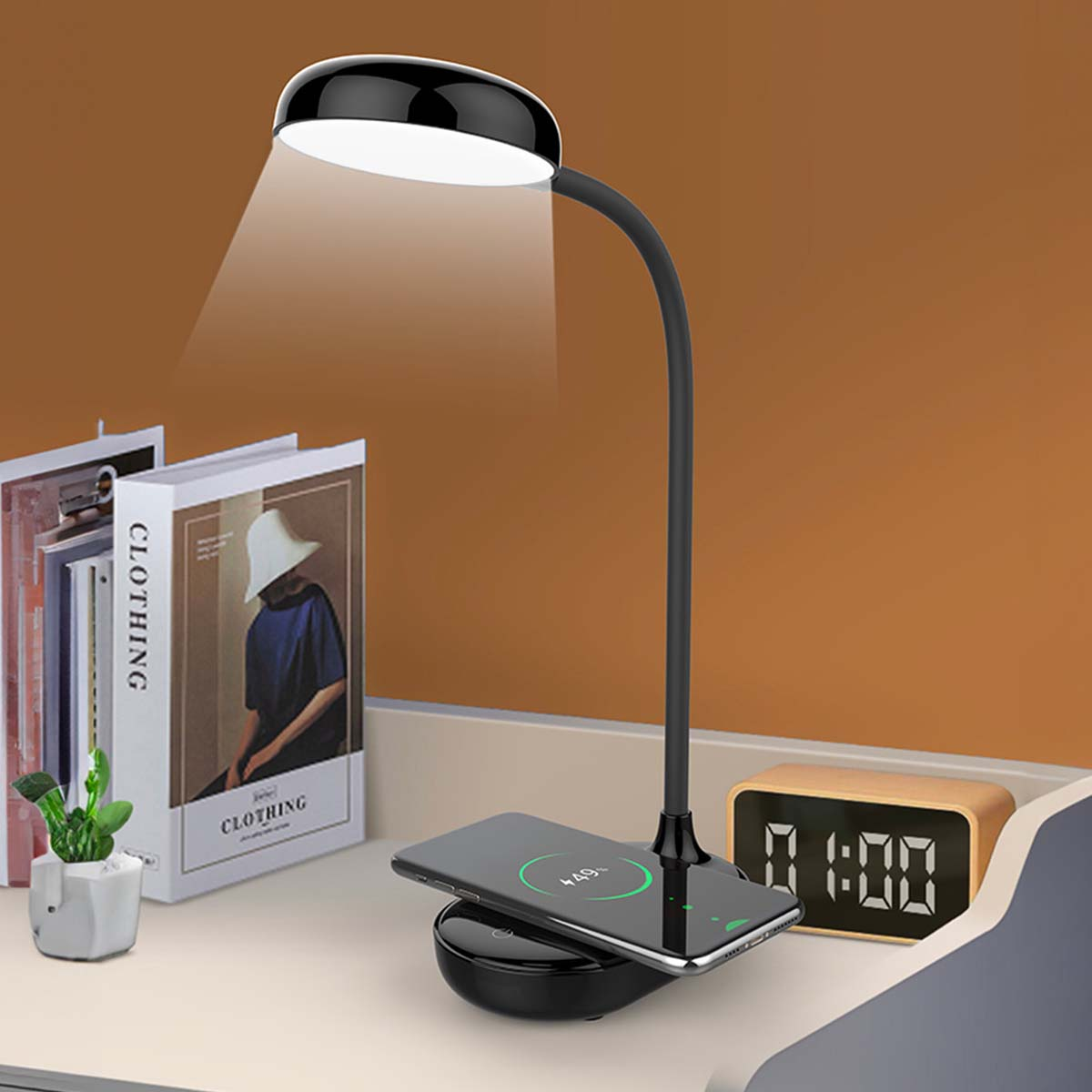 Lámpara de escritorio negra carga teléfono junto a libros y reloj en escritorio.