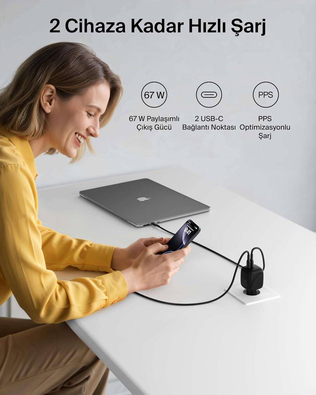 Donna carica laptop e telefono con 67W tramite adattatore USB-C.