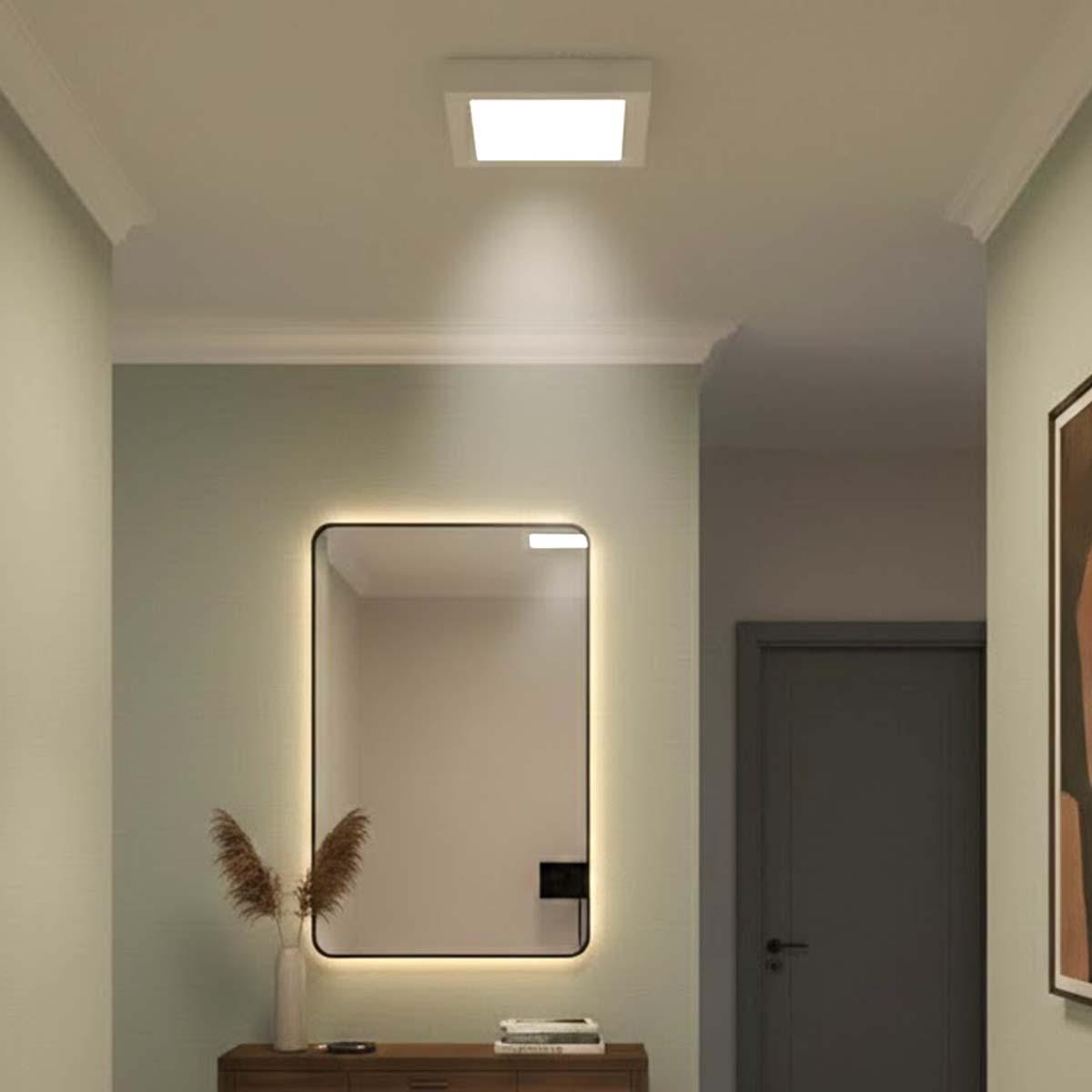 Un espejo rectangular con luces se encuentra en una cómoda en un pasillo.