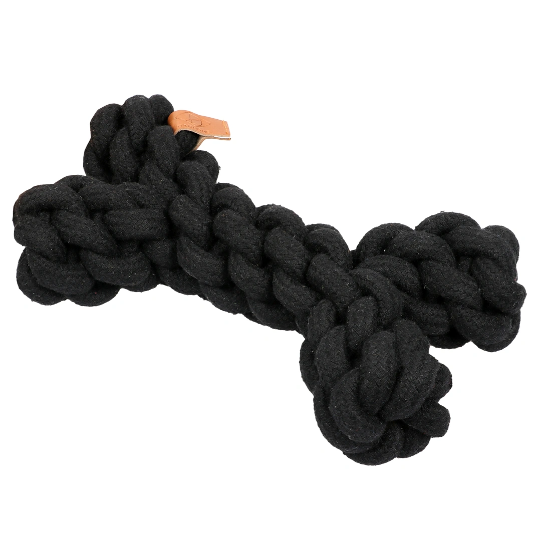 Giocattolo di corda nero a forma di osso con una piccola etichetta in pelle marrone.