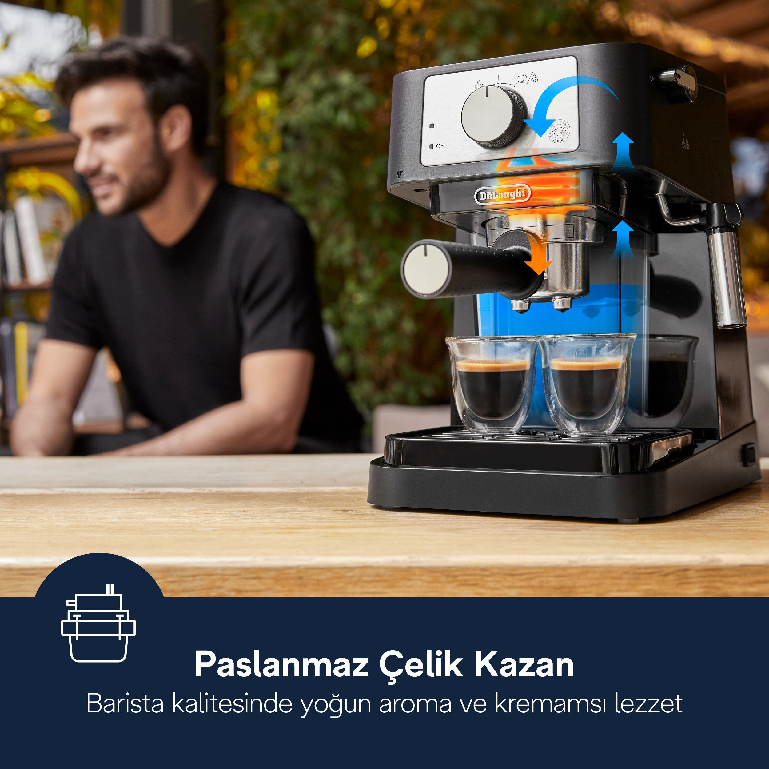 Een man achter een espressomachine die koffie maakt in twee kopjes.