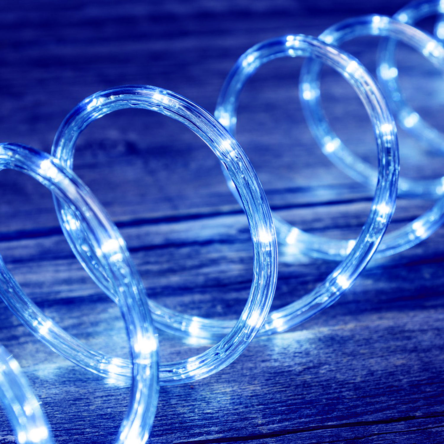Luci a corda LED blu su superficie di legno.