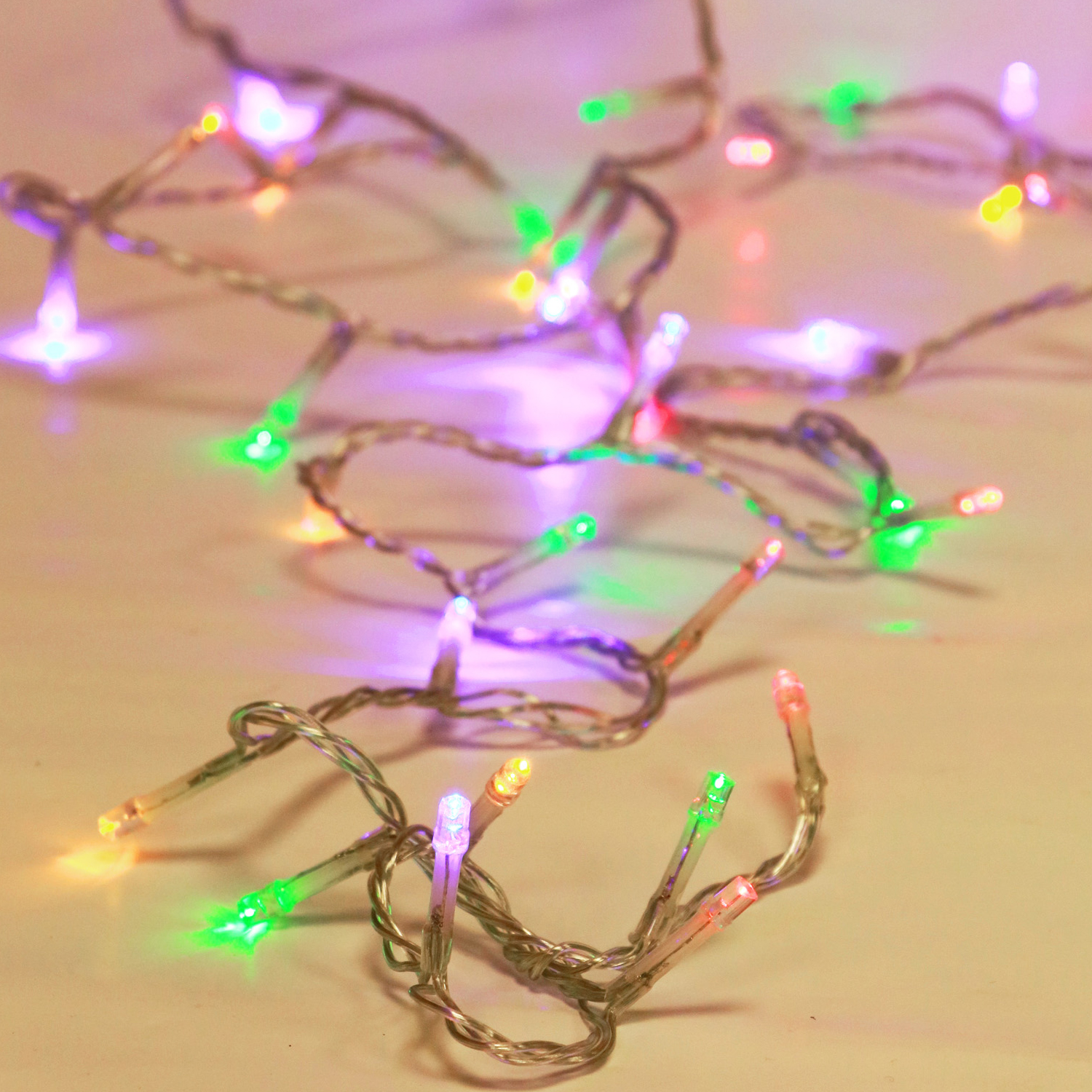 Una cadena de luces LED de colores sobre un fondo claro.