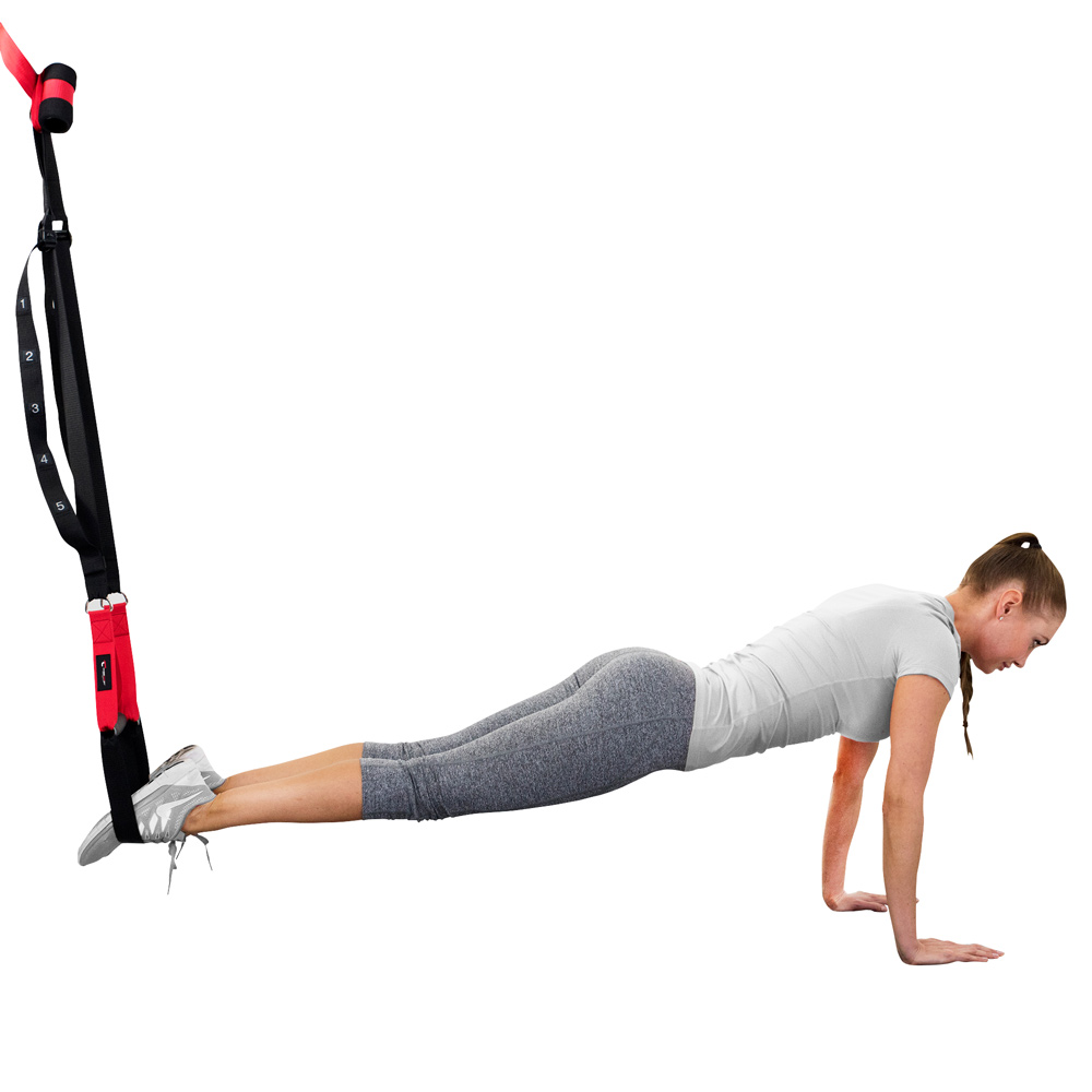 Frau macht Klimmzüge mit Fitnessband, Füße eingespannt, weißer Hintergrund.