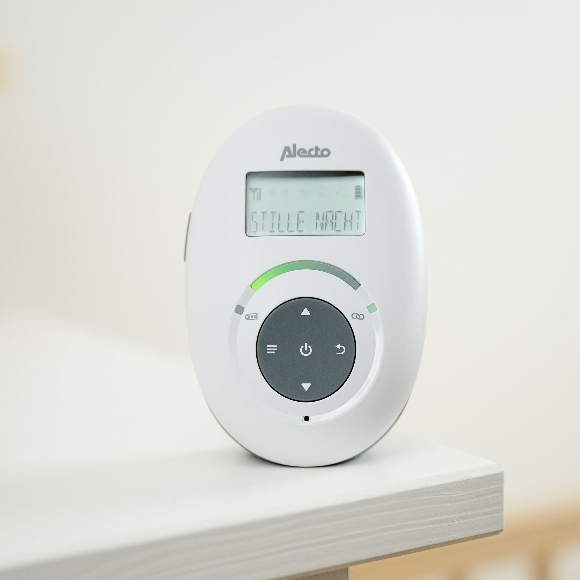 Ein weißer Alecto Baby Monitor mit Display, das 'STILLE NACHT' anzeigt.