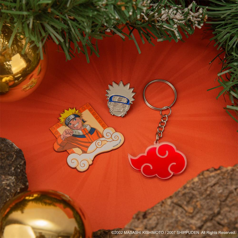 Naruto-Merchandise, darunter Anstecker und Schlüsselanhänger, auf orangefarbenem Hintergrund mit Deko.