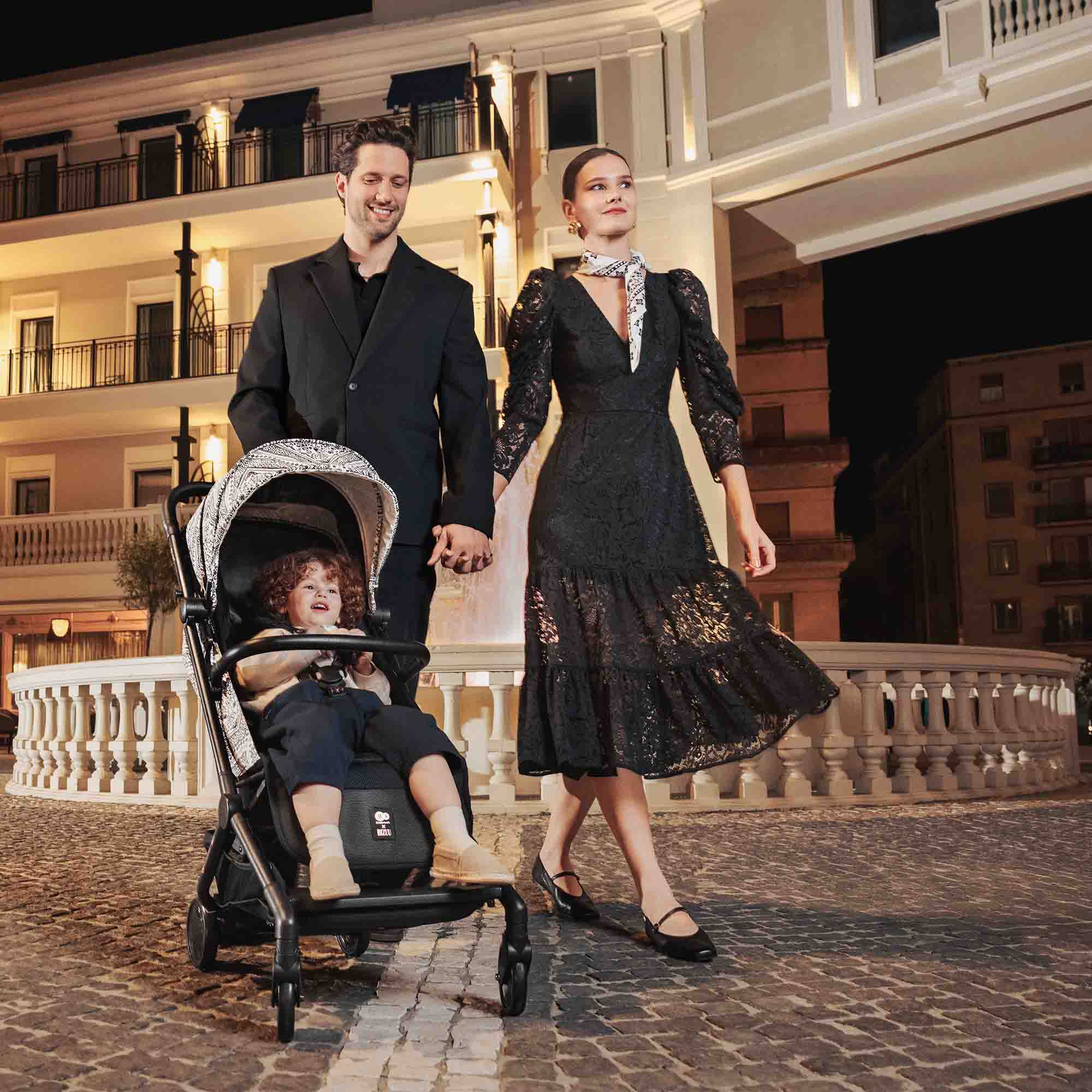 Ein Mann und eine Frau gehen mit einem Kinderwagen bei Nacht.