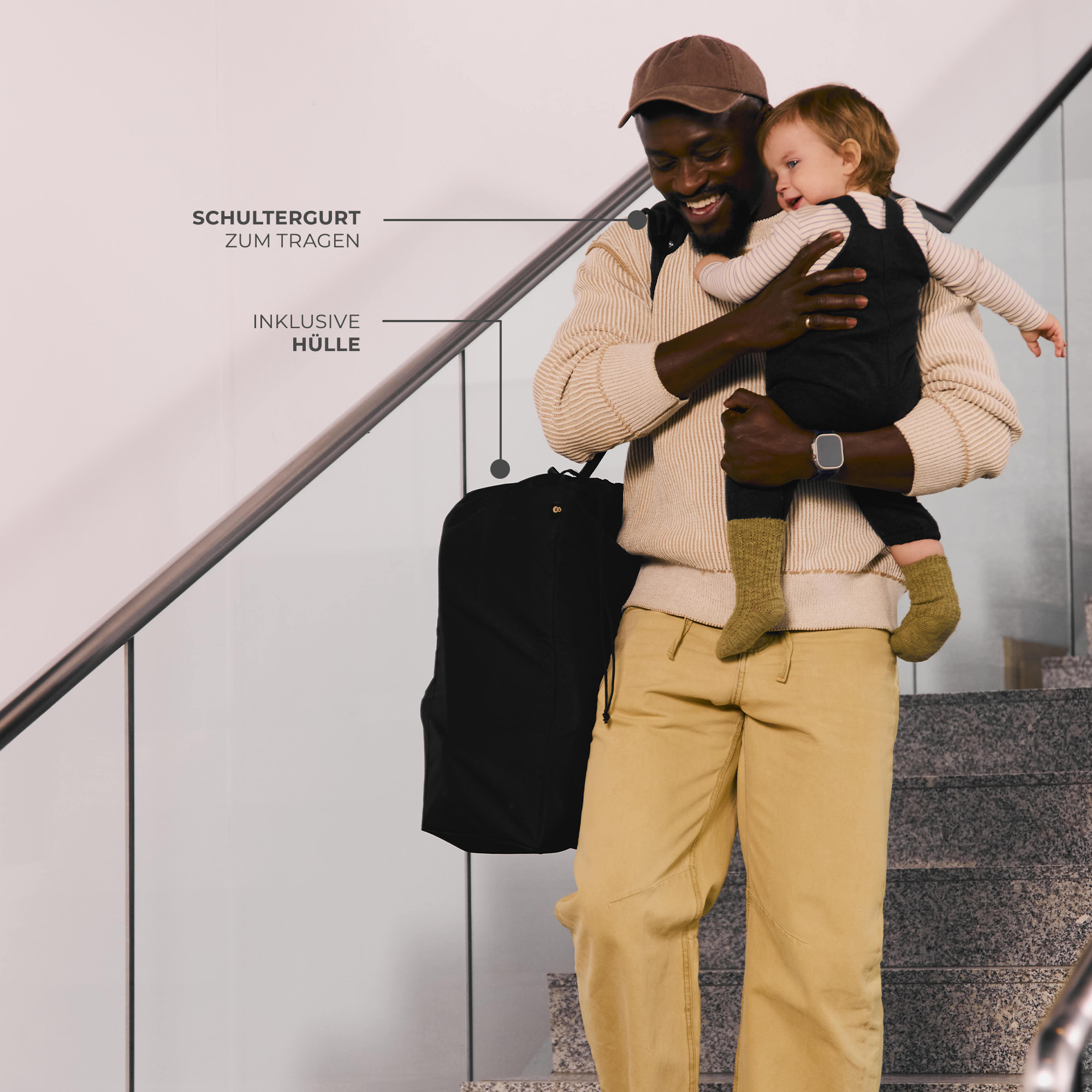 Mann mit Baby auf Treppe, schwarzer Rucksack, Kleidung mit Text.