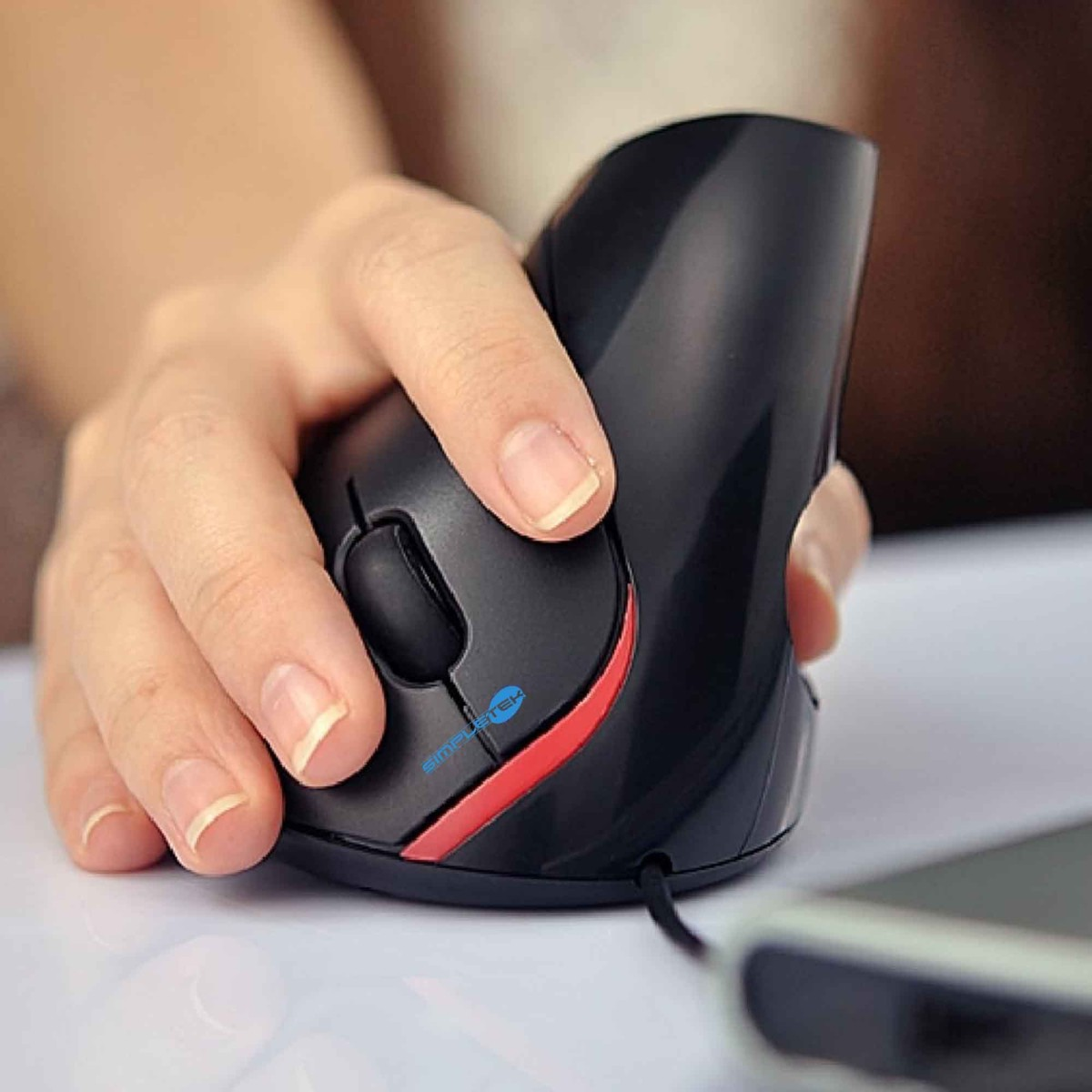Dłoń trzyma pionową czarną mysz z czerwonymi akcentami.