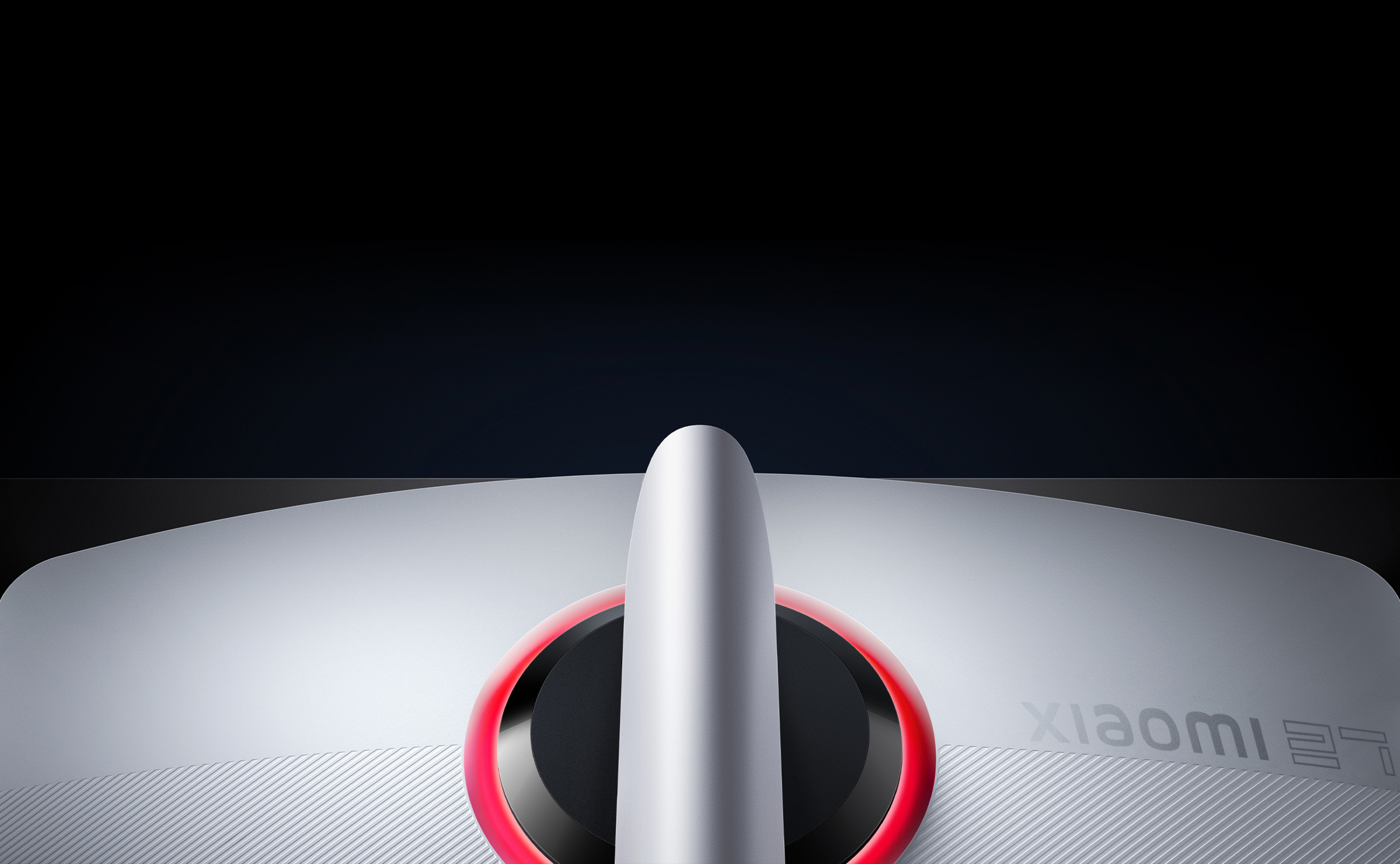 Srebrny stojak monitora z czerwonym podświetleniem i logo Xiaomi.
