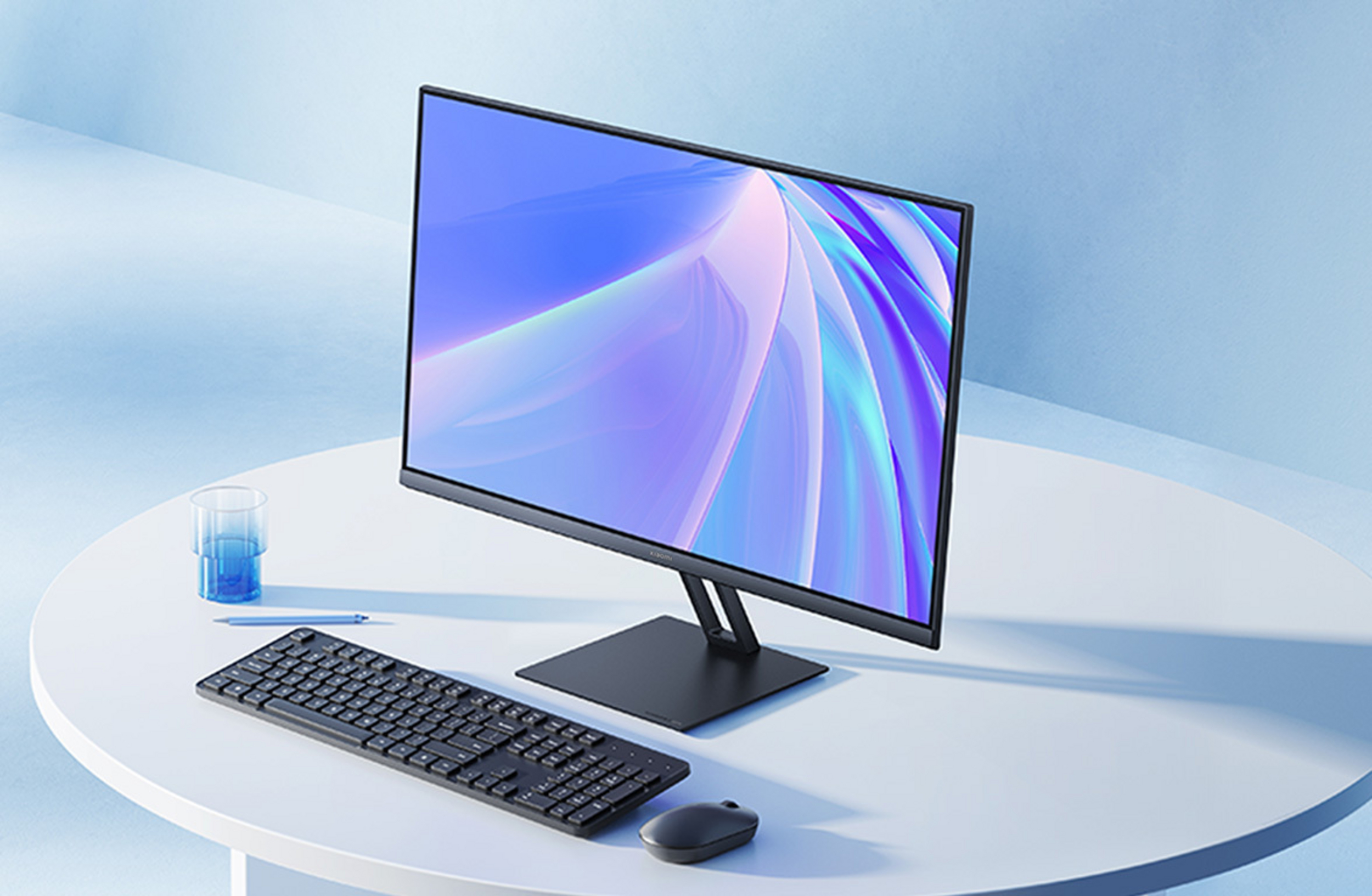 Ein moderner Desktop-Computer mit Tastatur, Maus und Glas auf einem weißen Tisch.