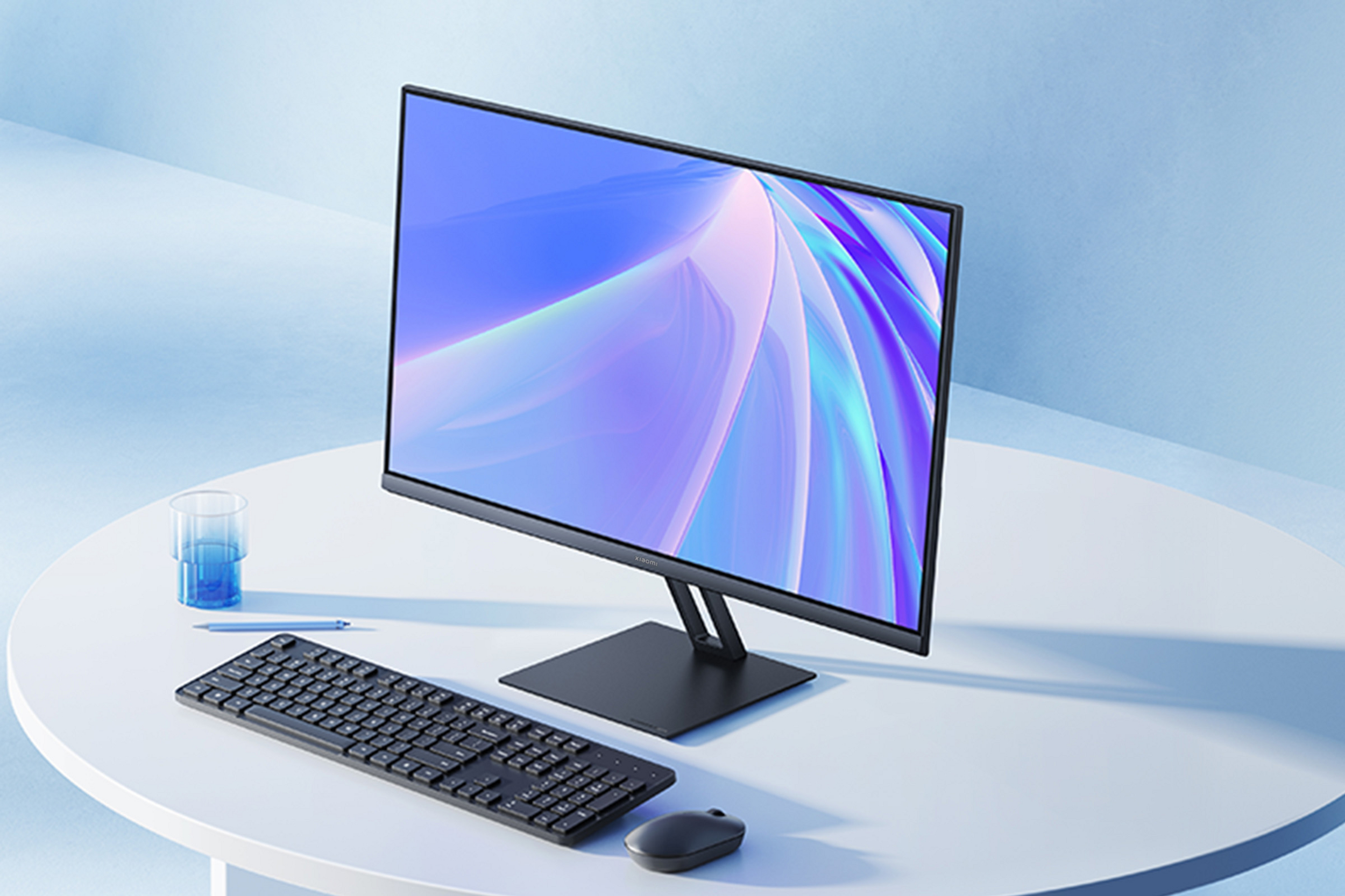 Ein schlanker Computermonitor, Tastatur, Maus, Stift und Glas mit blauer Flüssigkeit auf weißem Tisch.