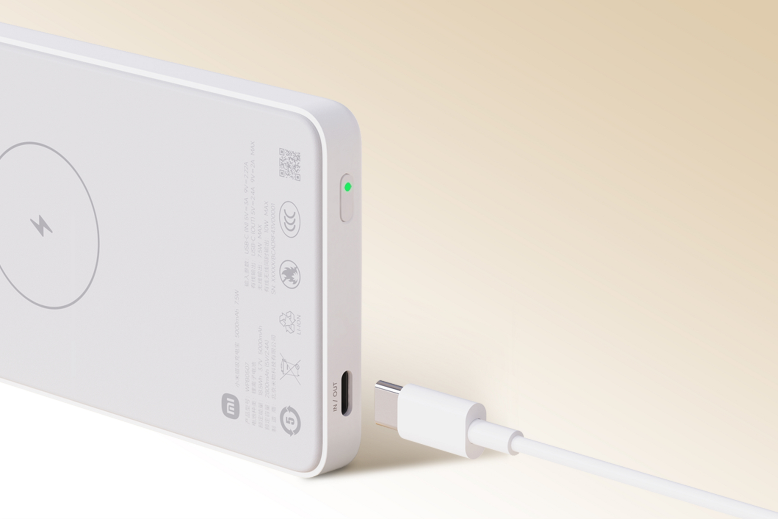 Biała powerbanka Mi z kablem USB-C i zielonym wskaźnikiem.