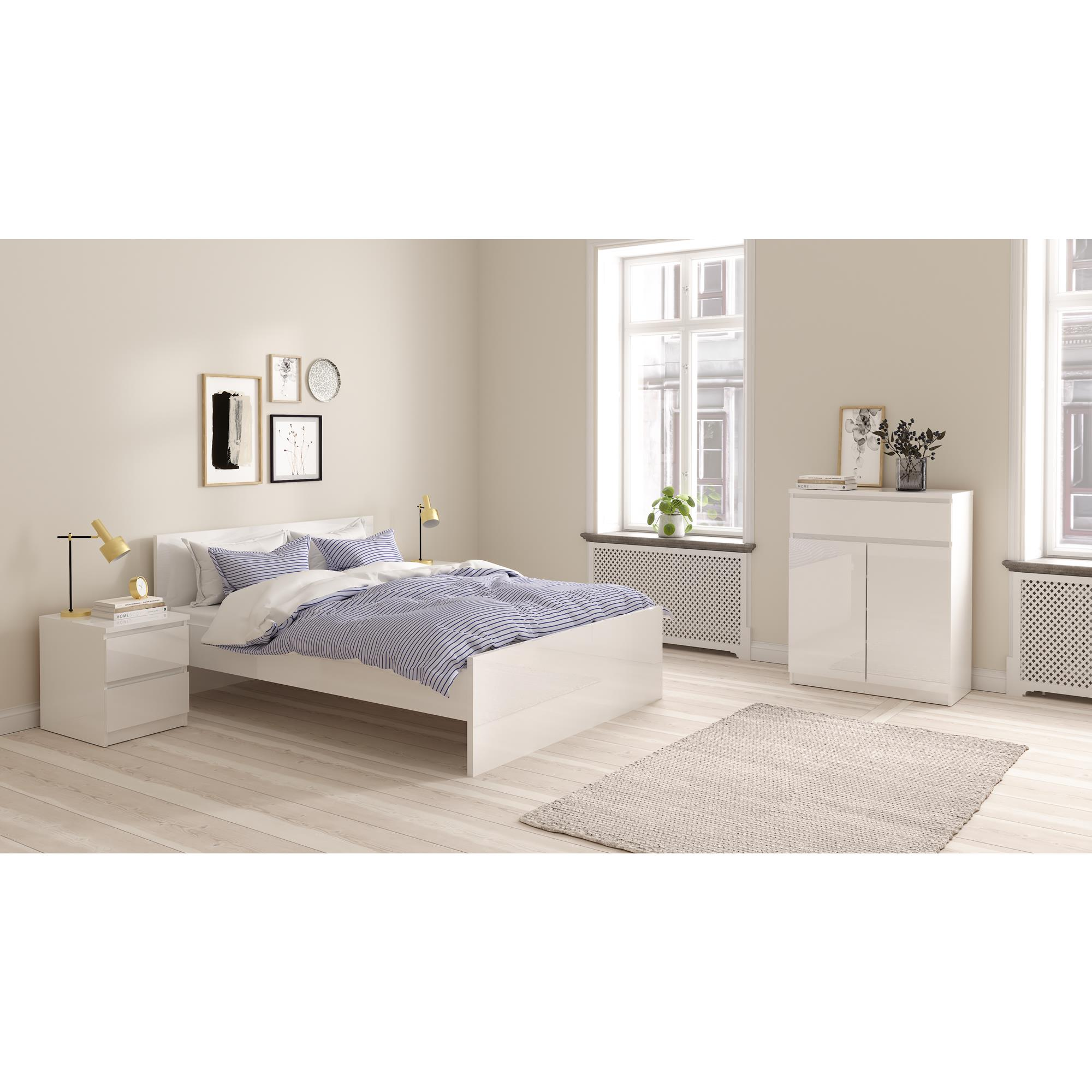 Dormitorio moderno con cama blanca, ropa de cama a rayas y mesitas de noche.