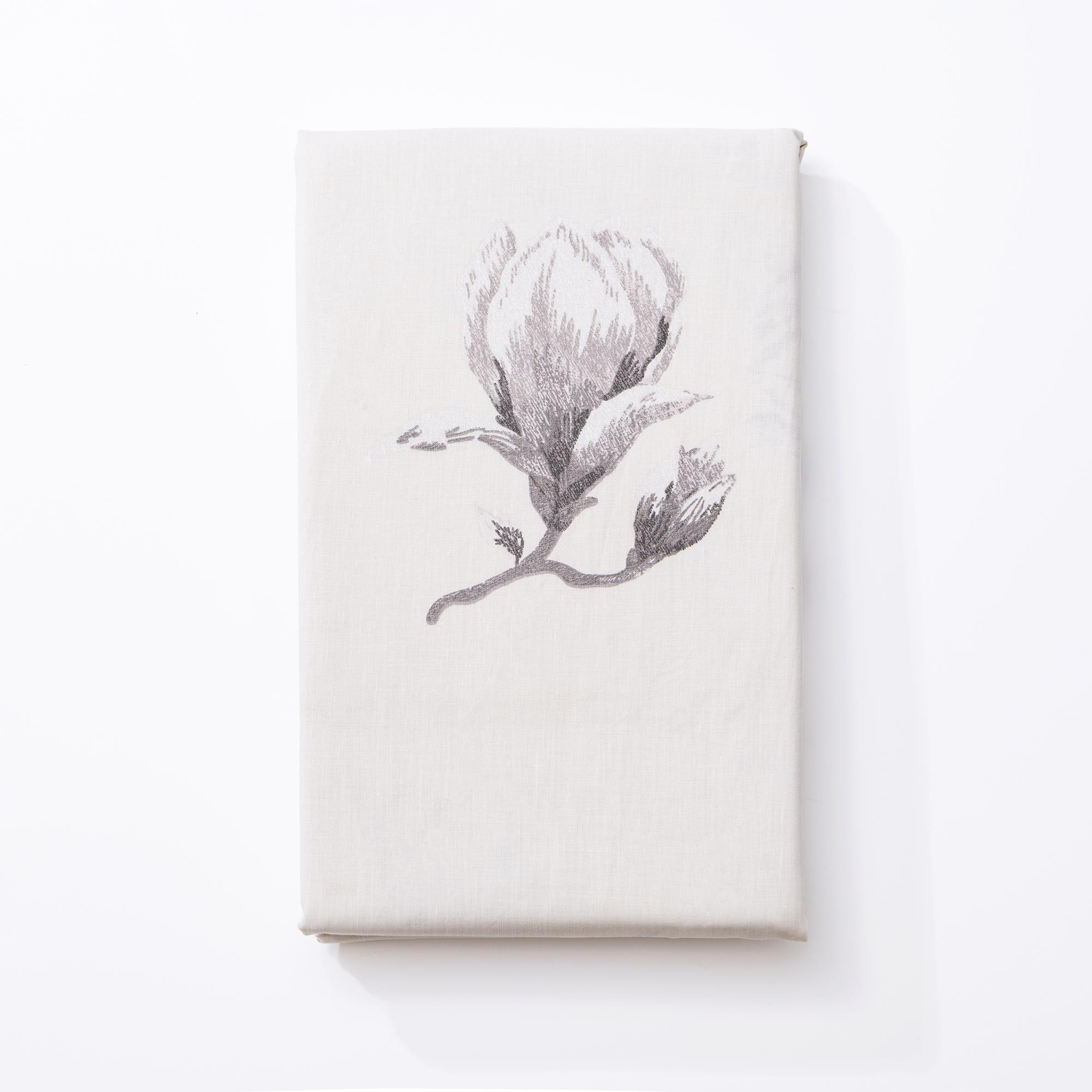 Un paño enrollado de color crema con estampado de magnolia gris.